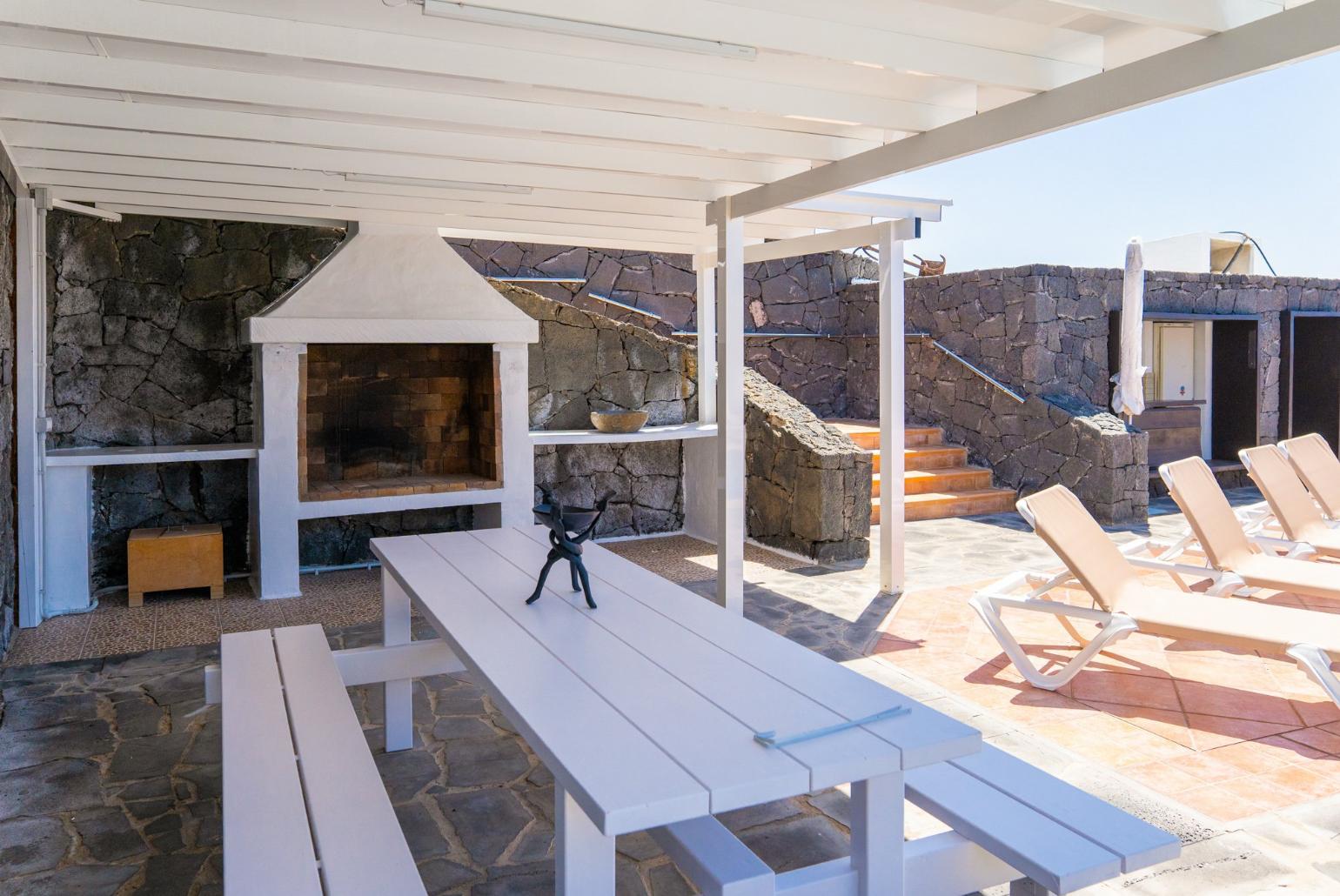Pool area with sunbeds,sheltered dining area and outdoor BBQ