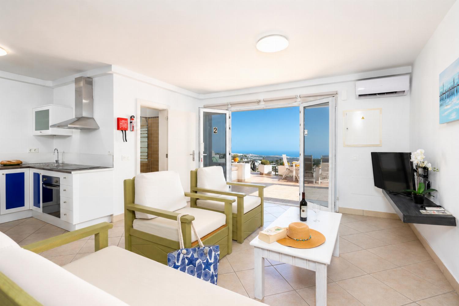 Unit 2: open-plan living room with sofa, dining area, kitchen, A/C, WiFi internet, satellite TV, and sea views