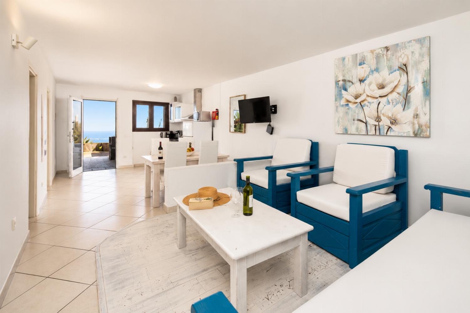 Unit 1: open-plan living room with sofa, dining area, kitchen, WiFi internet, and satellite TV