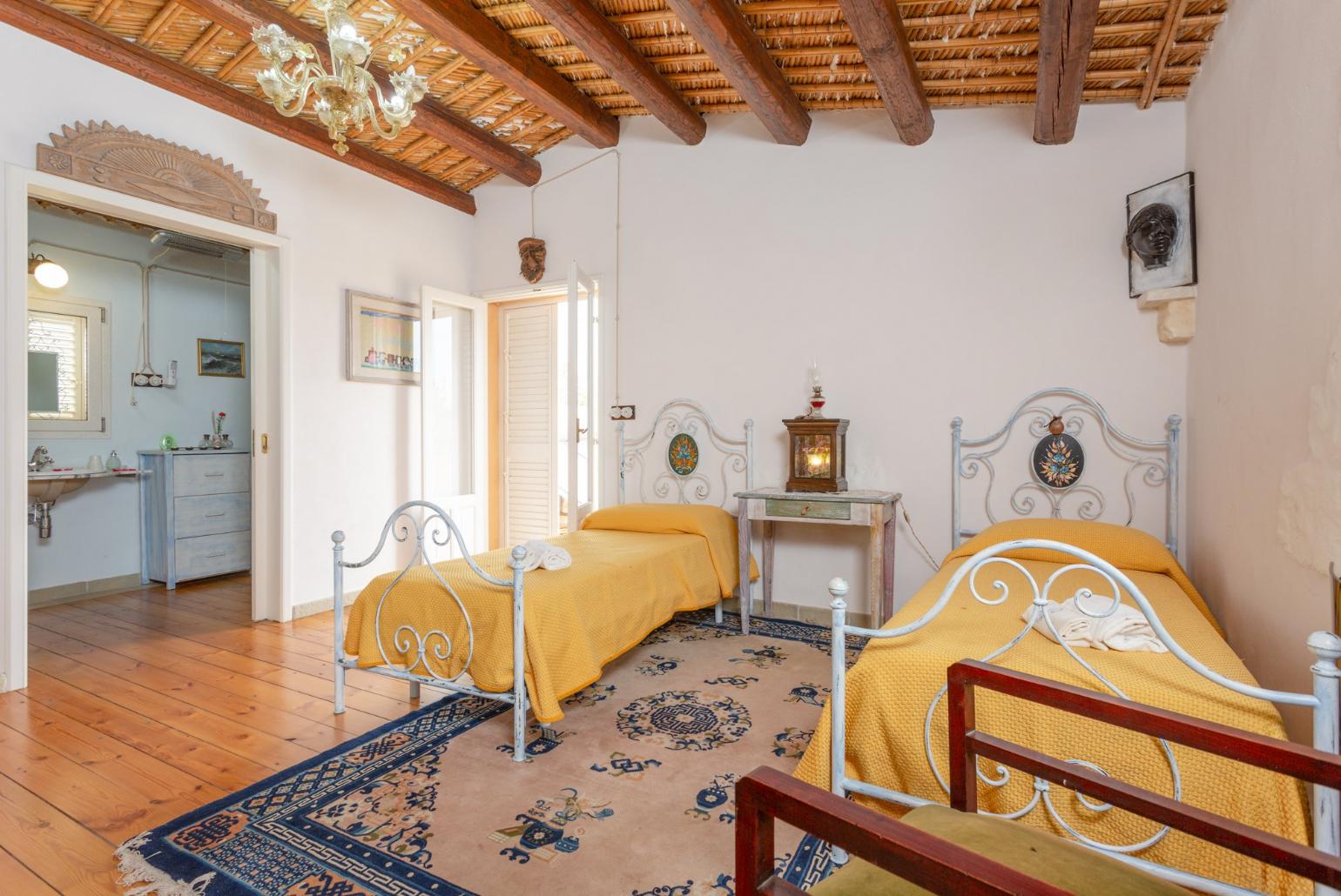 Twin bedroom with en suite bathroom and balcony access