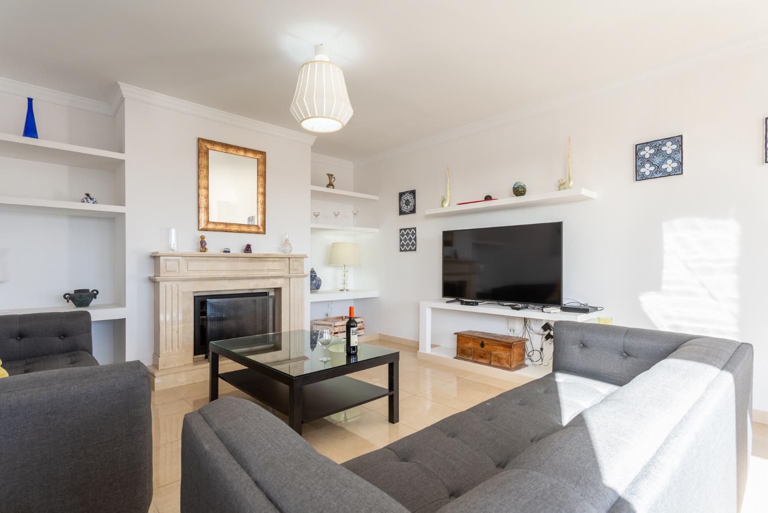 Living room with sofas, dining area, ornamental fireplace, A/C, WiFi internet, and satellite TV