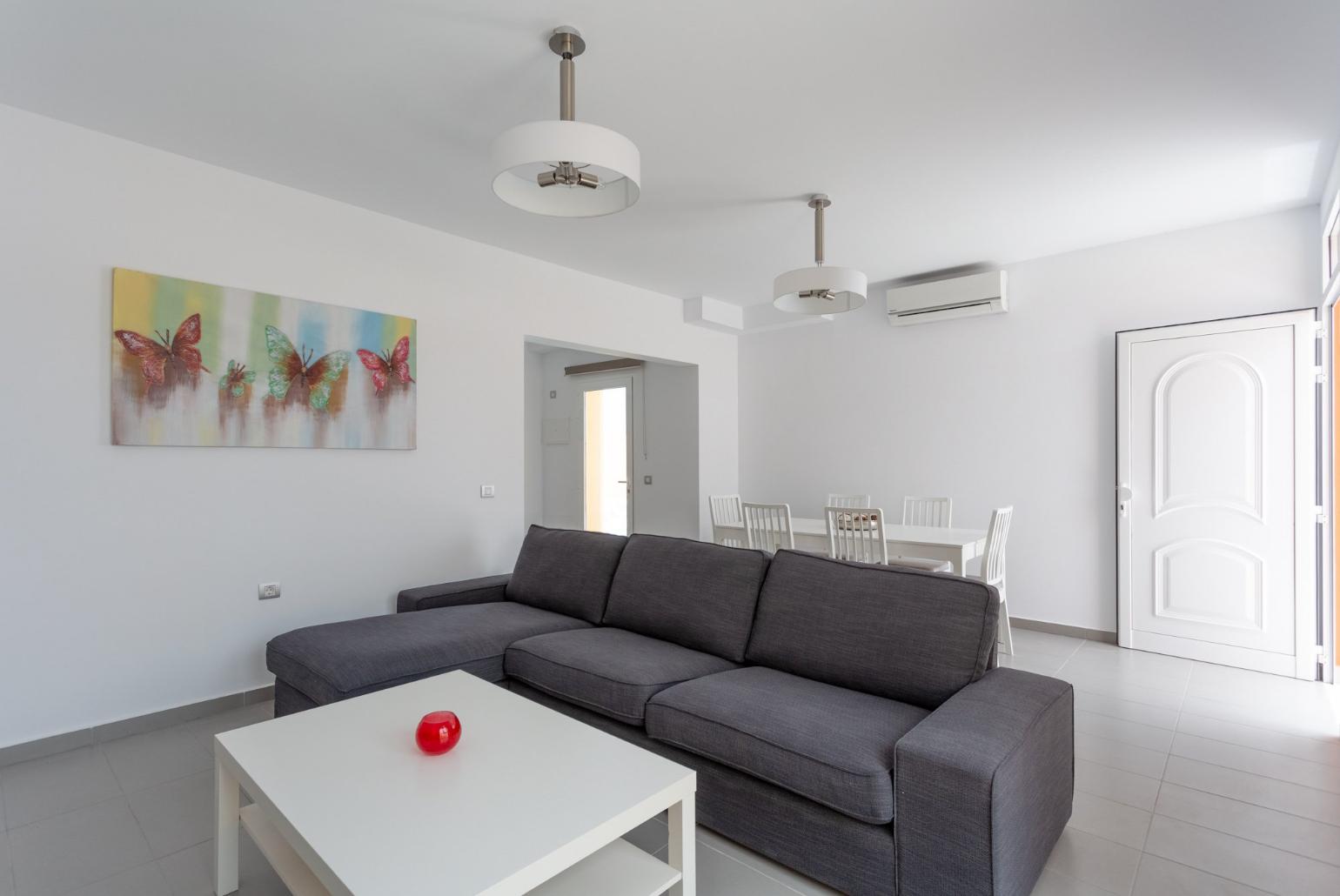 The Air Conditioned living room with sofas, WiFi Internet, Satellite TV and dining area.