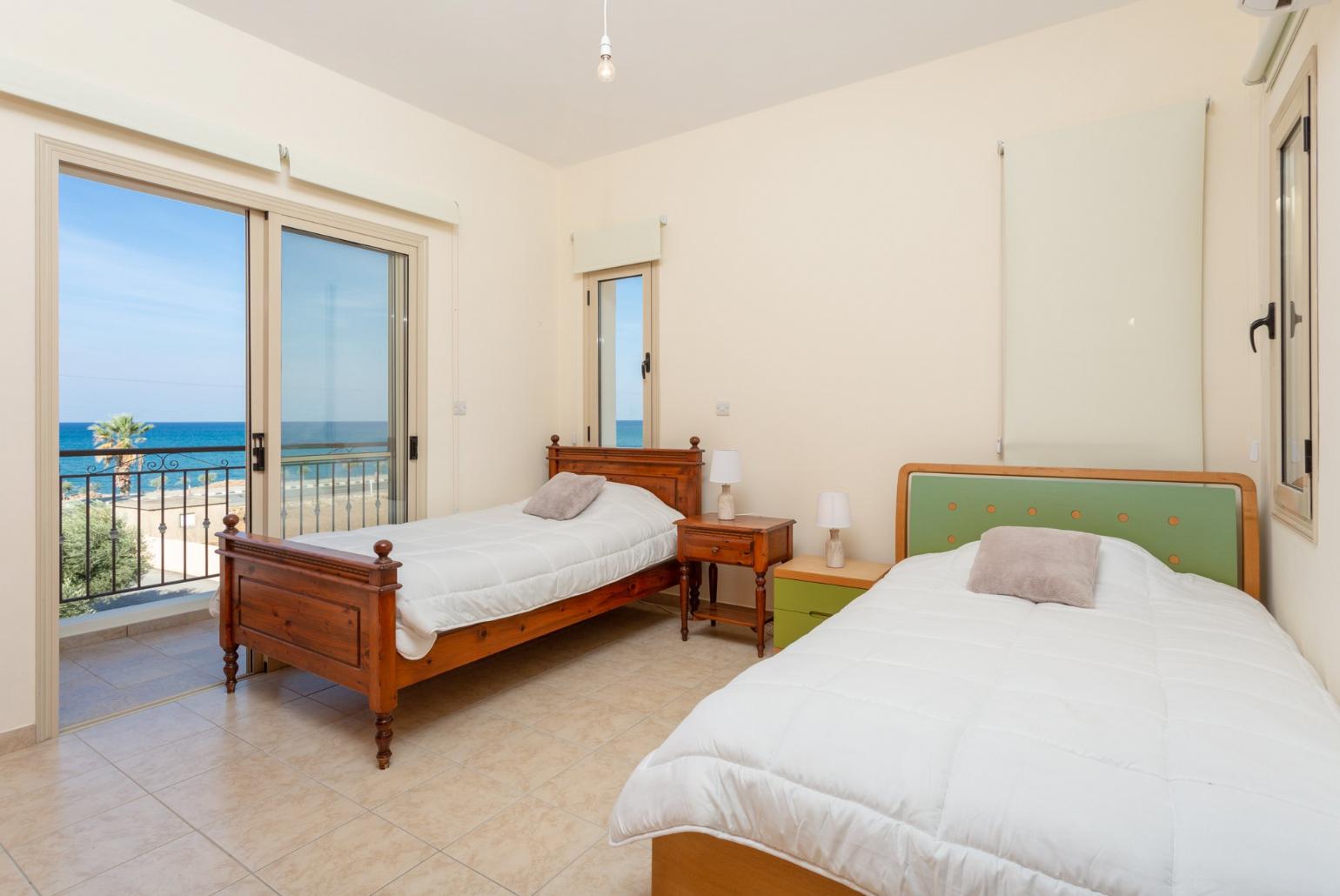 Twin bedroom with en suite bathroom, A/C, and balcony with sea views