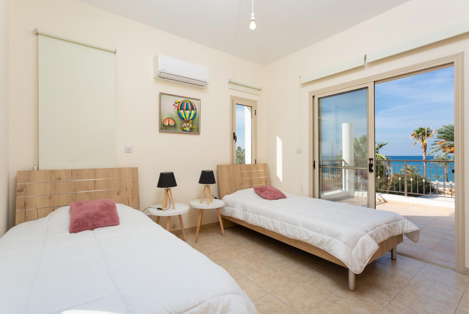 Twin bedroom with en suite bathroom, A/C, and balcony with sea views