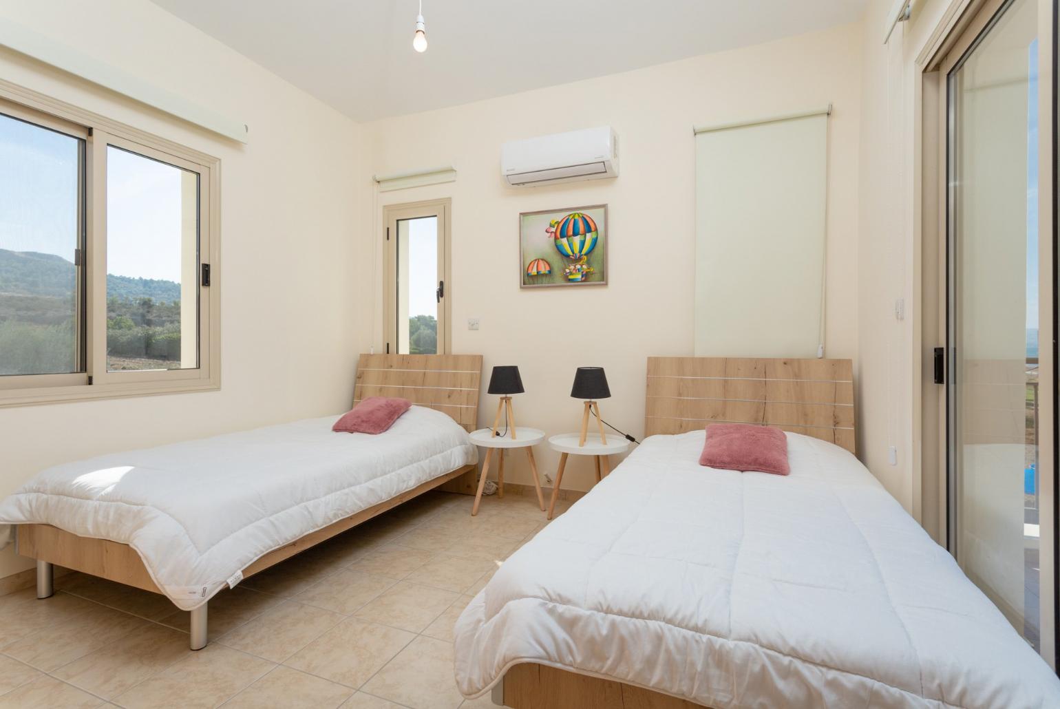 Twin bedroom with en suite bathroom, A/C, and balcony with sea views