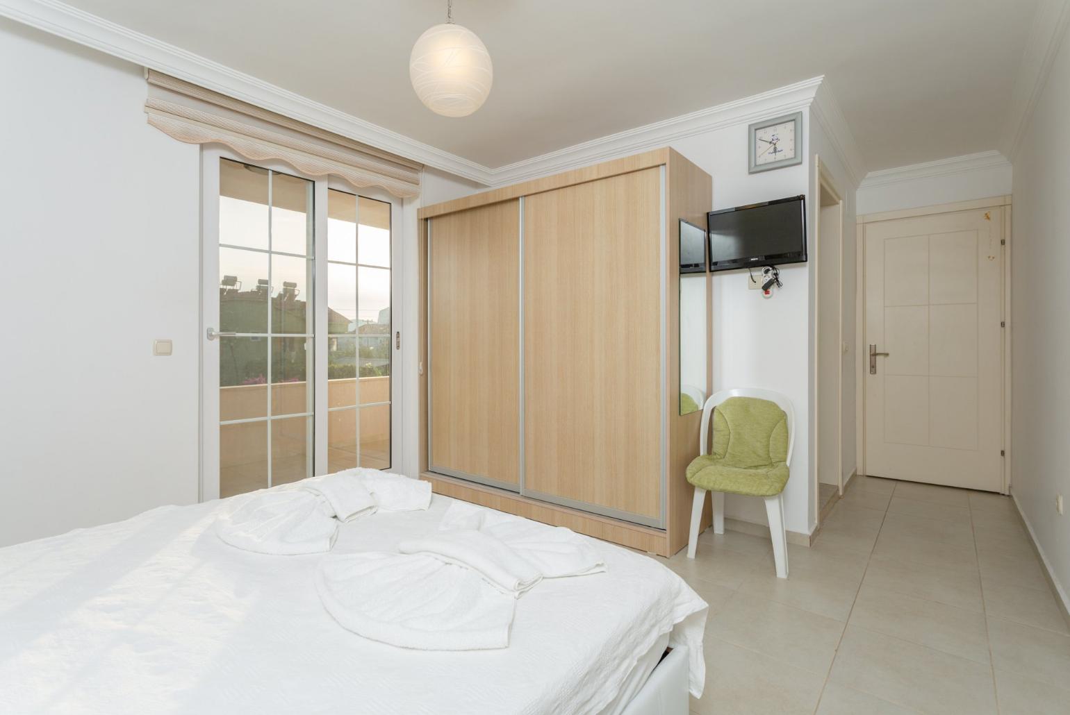 Double bedroom with en suite bathroom, A/C, TV, and balcony access