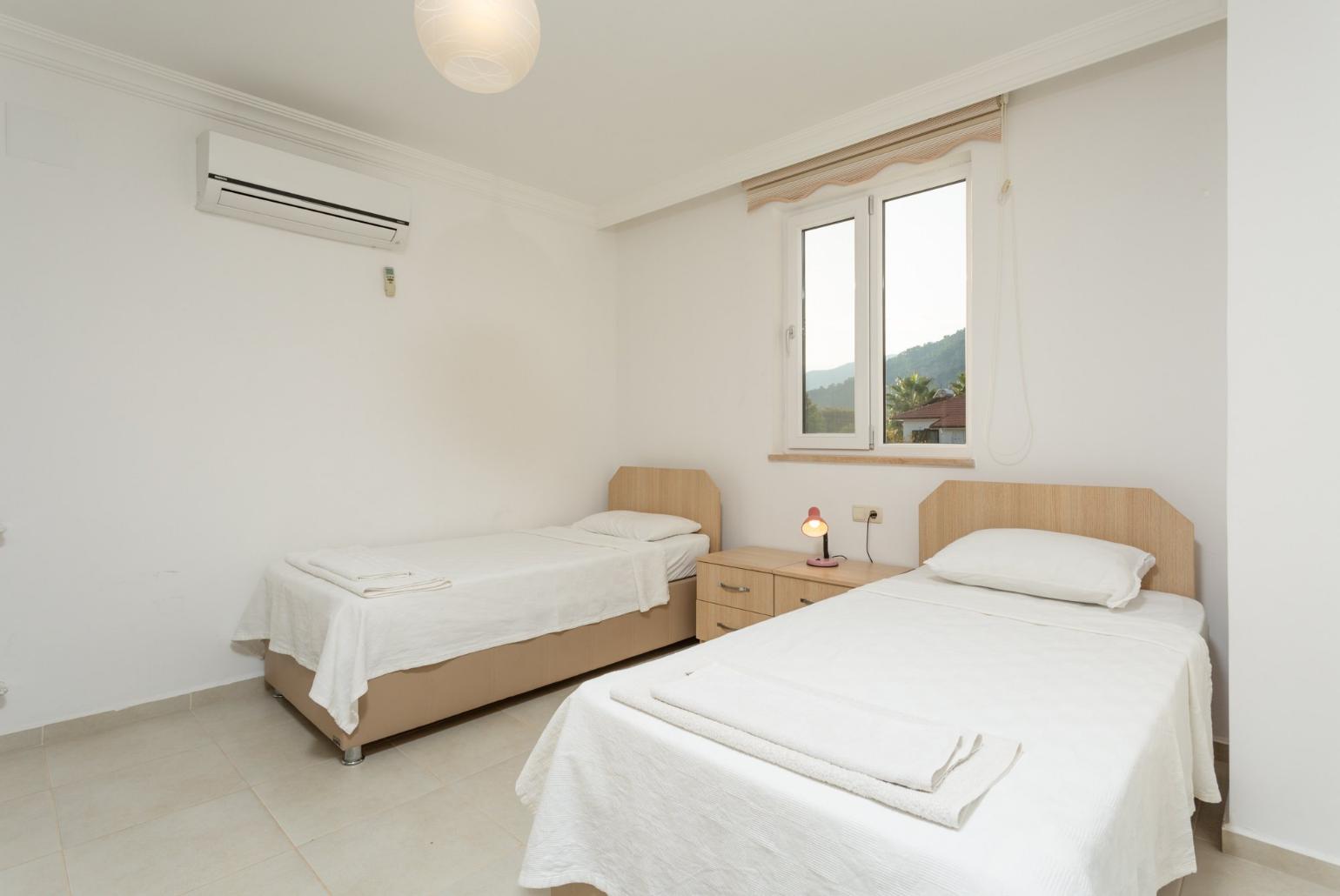 Twin bedroom with en suite bathroom, A/C, and balcony access