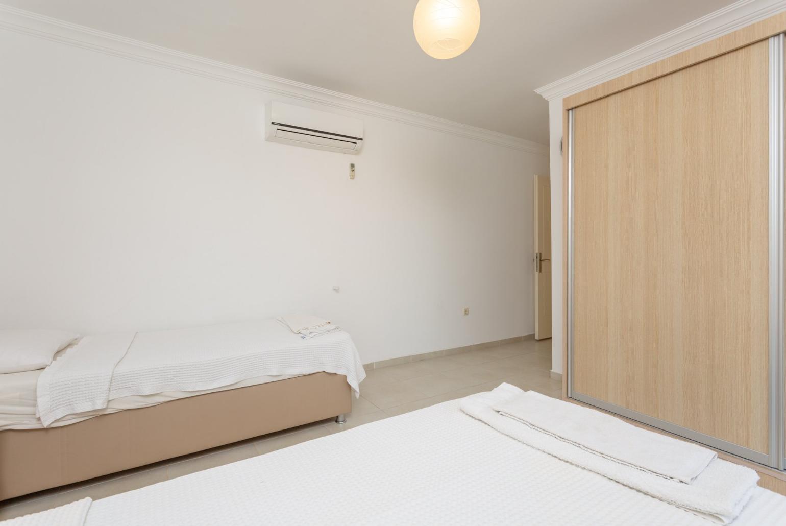 Twin bedroom with en suite bathroom, A/C, and balcony access