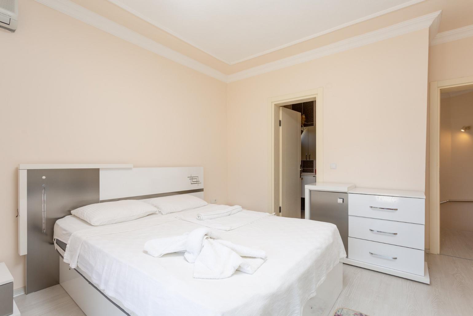 Double bedroom with en suite bathroom, A/C, and balcony access