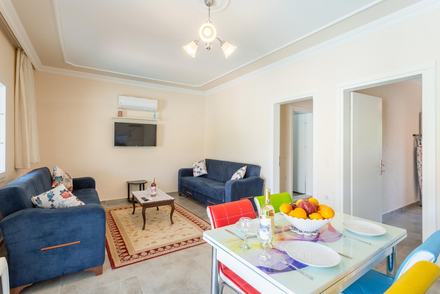 Open-plan living room with sofas, dining area, kitchen, A/C, WiFi internet, satellite TV, and terrace access