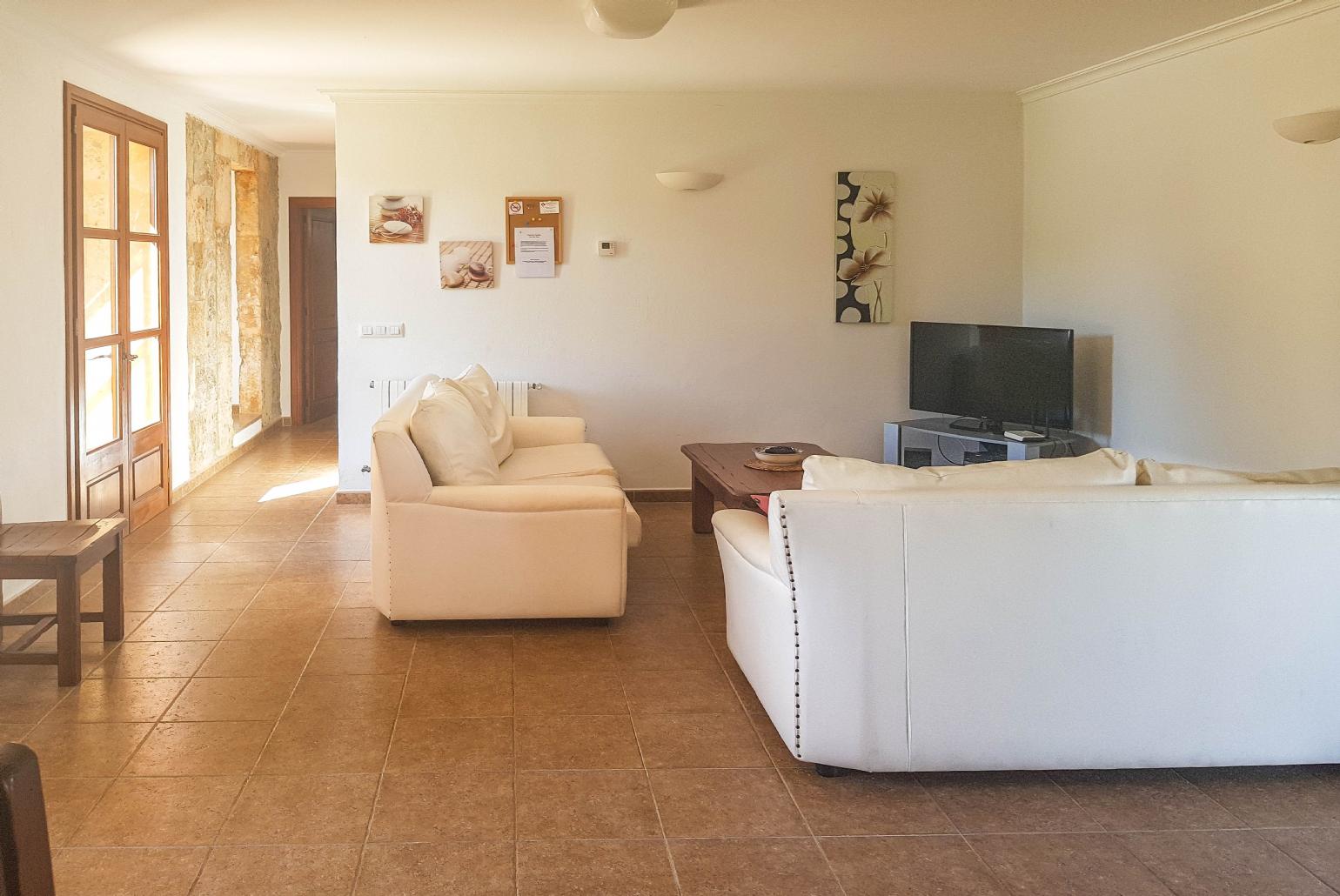 Open-plan living room with sofas, WiFi Internet, Satellite TV, DVD player and dining area. 