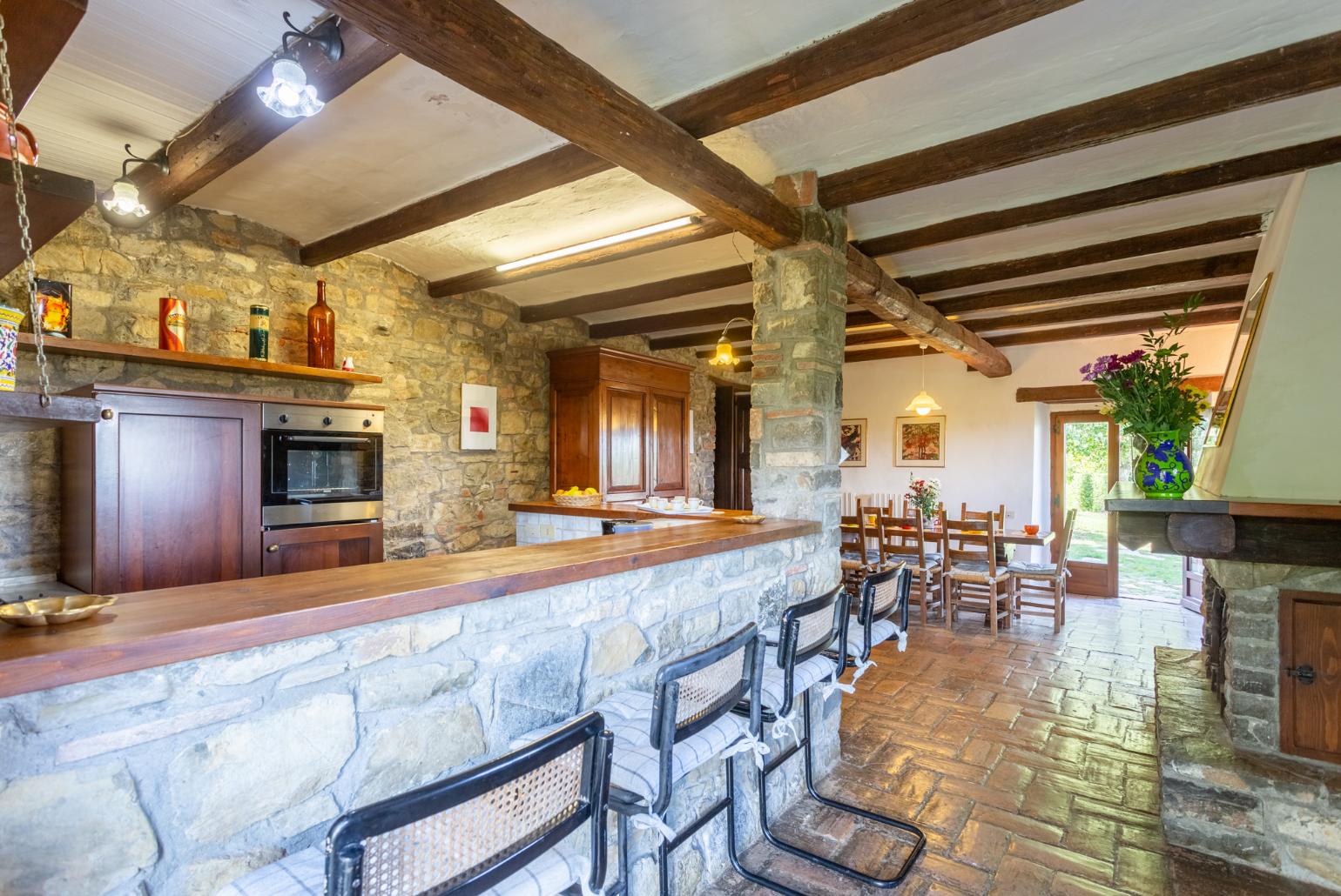 Open-plan dining area with equipped kitchen and ornamental fireplace 