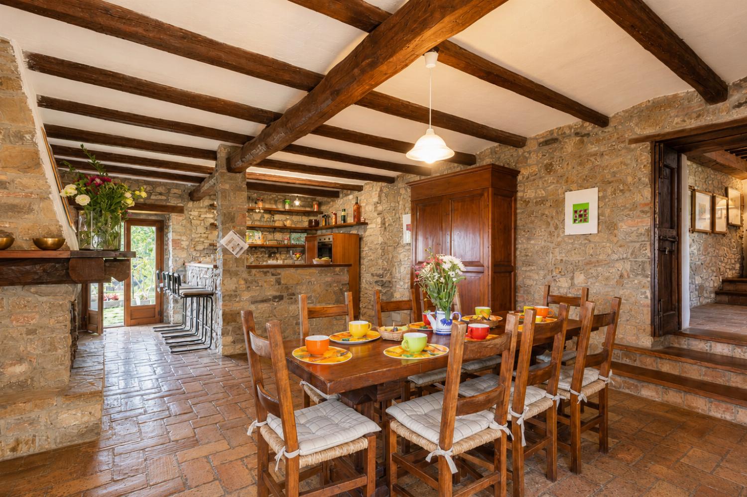 Open-plan dining area with kitchen and ornamental fireplace