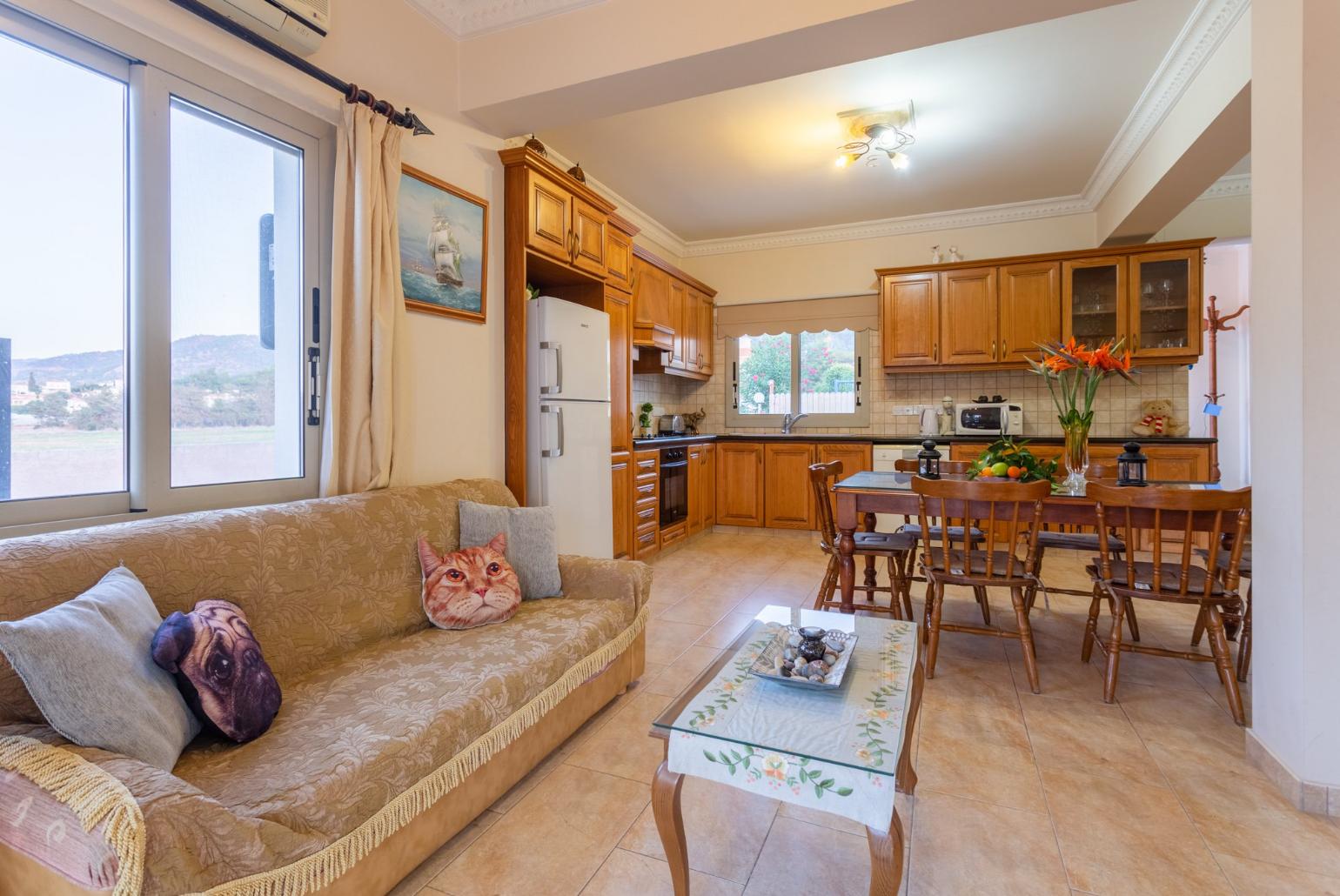 Open-plan living room with sofas, dining area, kitchen, A/C, WiFi internet, satellite TV, and pool terrace access