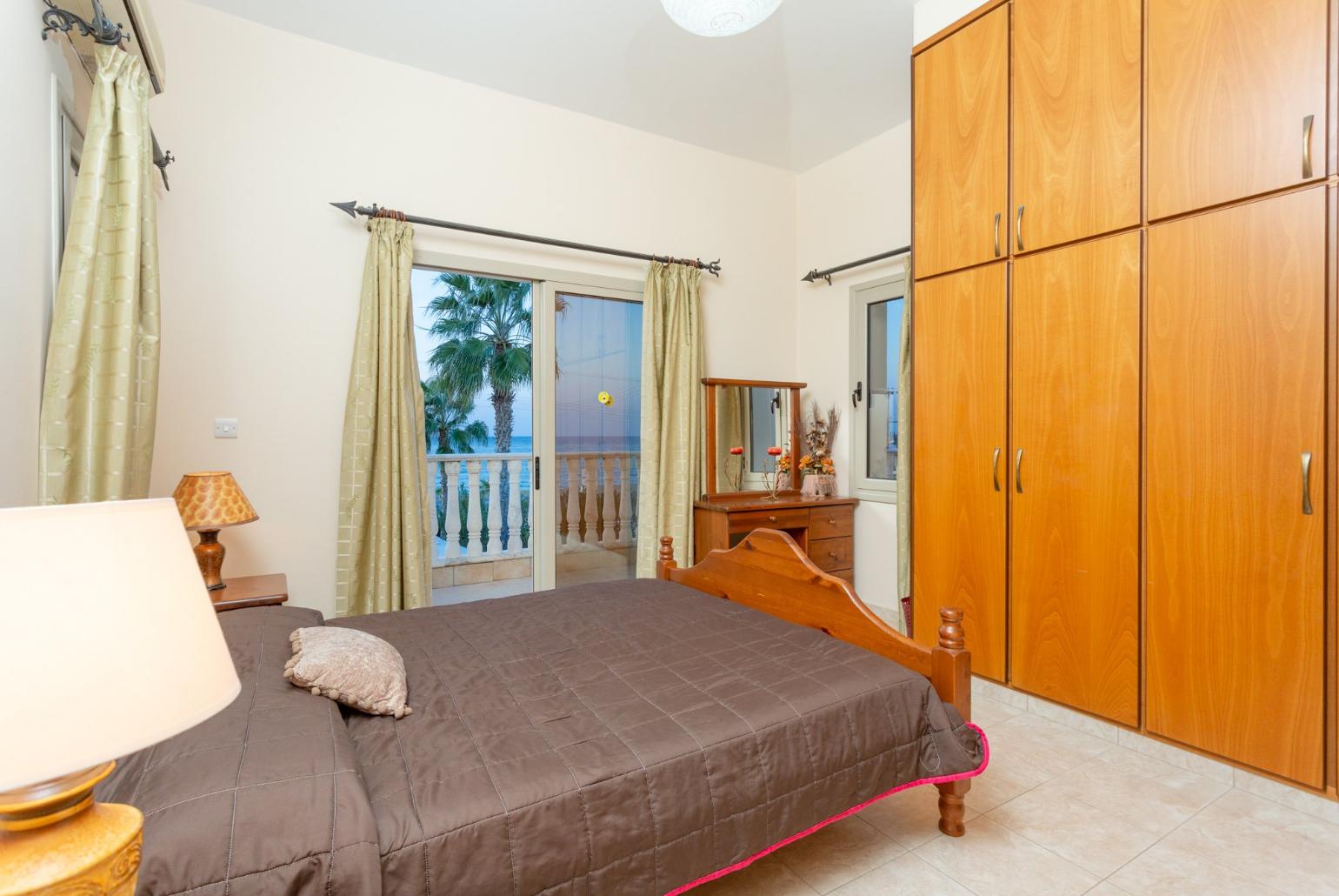 Double bedroom with en suite bathroom, A/C, and balcony with sea views