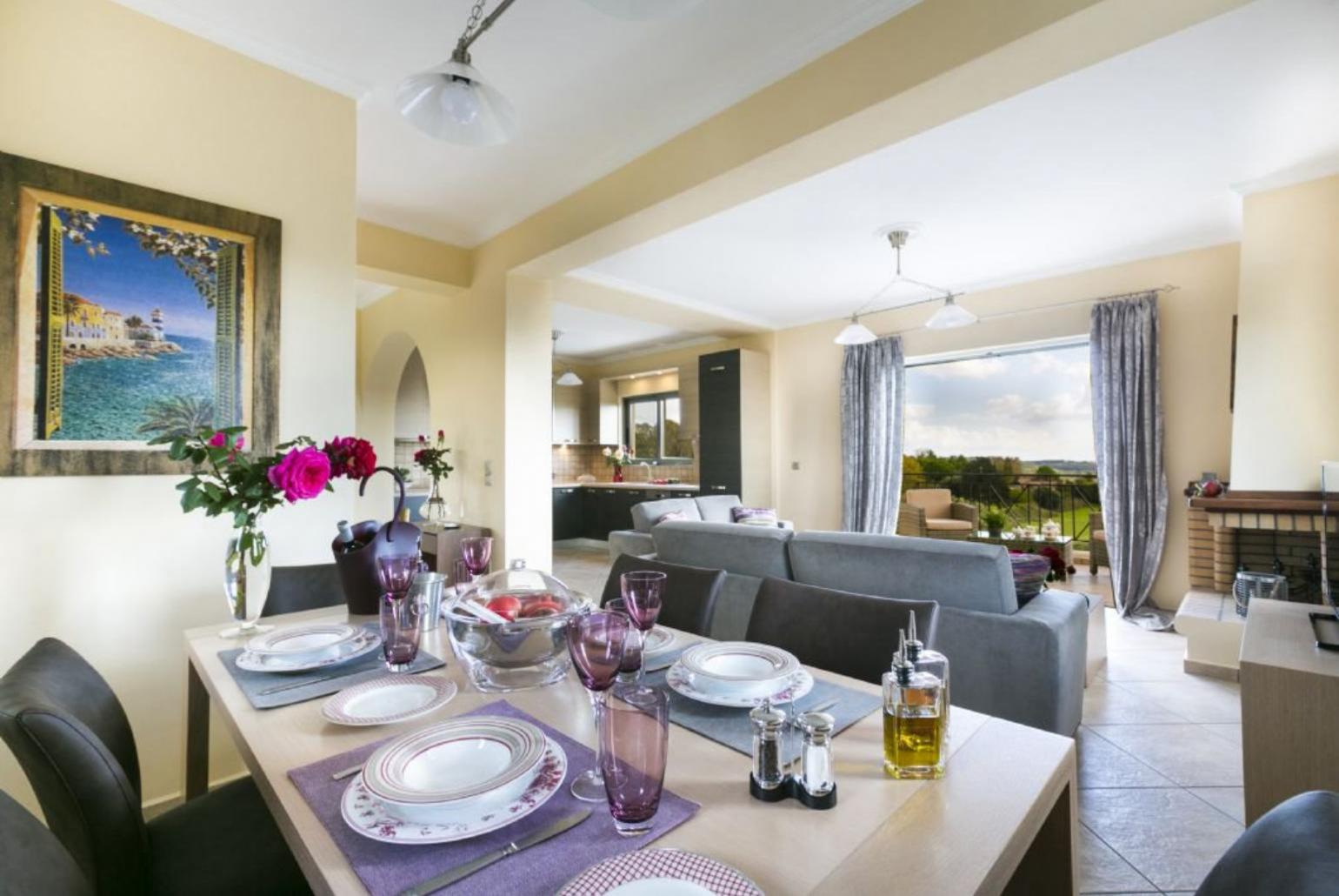 Open-plan living room with sofas, dining area, kitchen, ornamental fireplace, A/C, WiFi internet, satellite TV, DVD player, and sea views