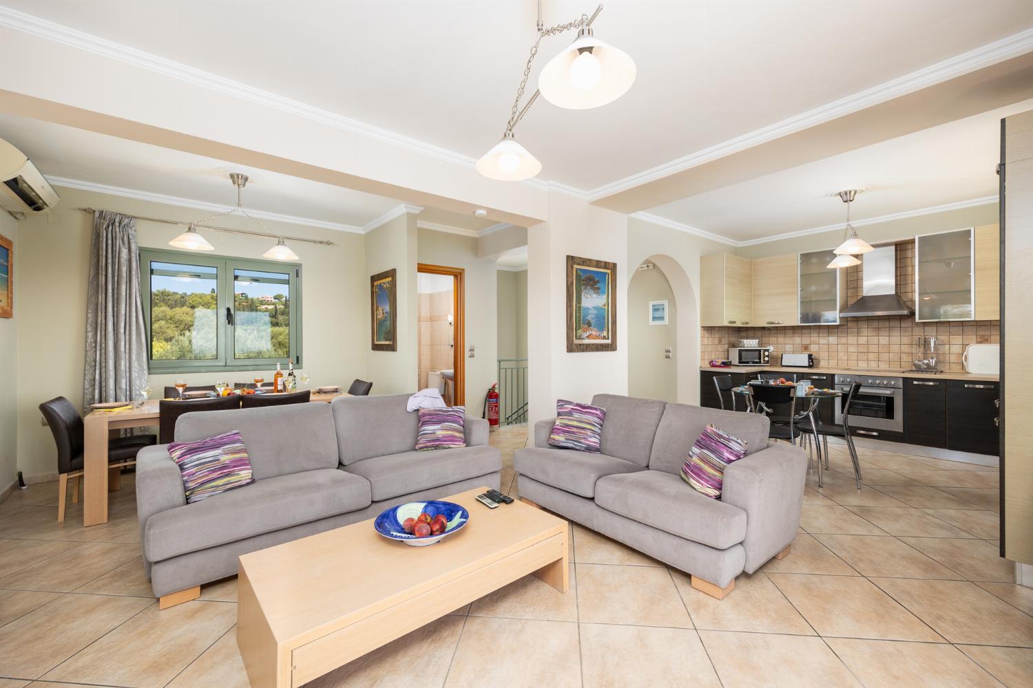Open-plan living room with sofas, dining areas, kitchen, ornamental fireplace, A/C, WiFi internet, satellite TV, and sea views