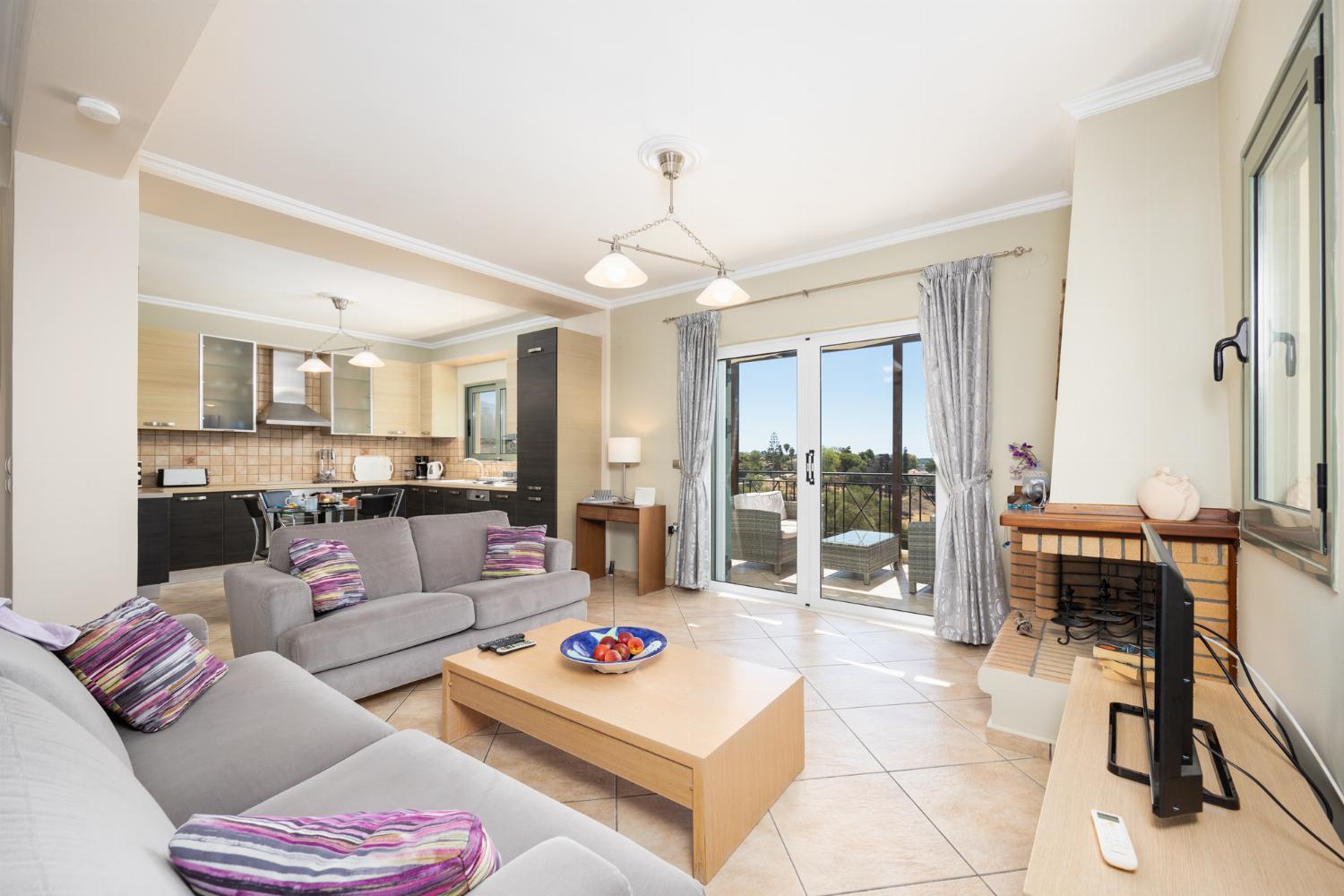 Open-plan living room with sofas, dining areas, kitchen, ornamental fireplace, A/C, WiFi internet, satellite TV, and sea views