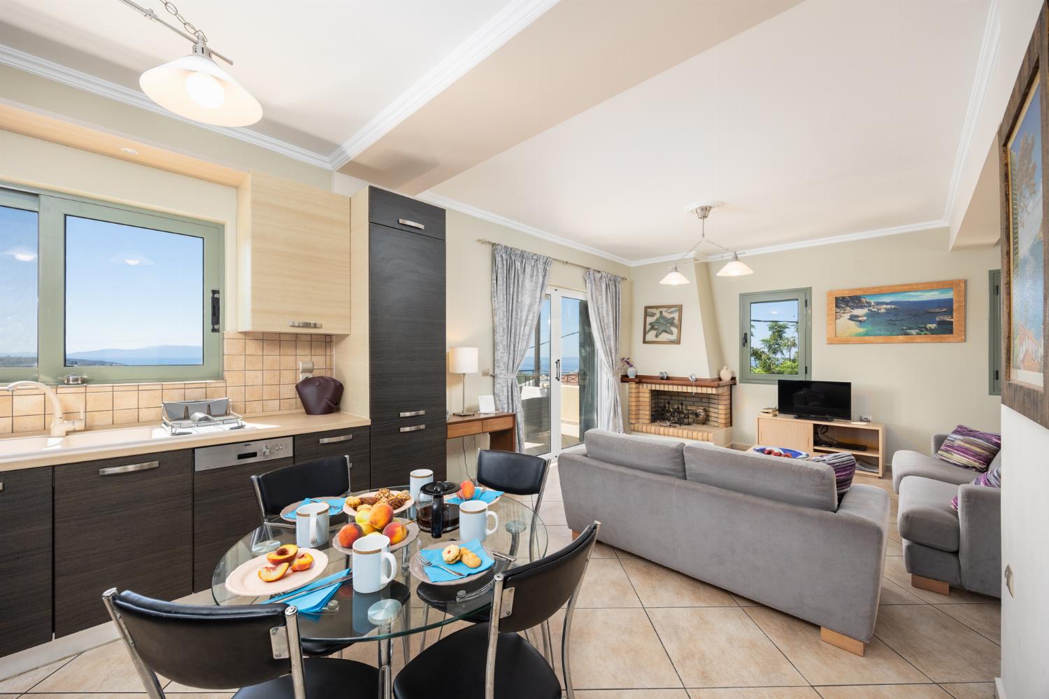 Open-plan living room with sofas, dining areas, kitchen, ornamental fireplace, A/C, WiFi internet, satellite TV, and sea views