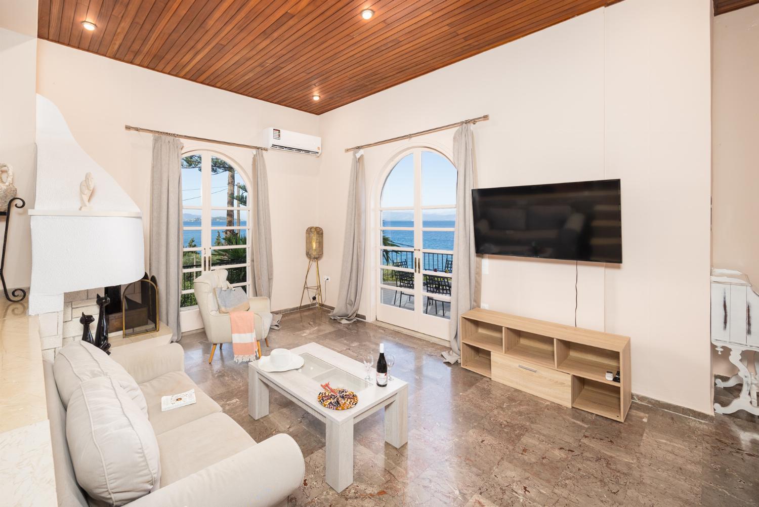 Living room with sofas, ornamental fireplace, A/C, WiFi internet, satellite TV, and sea views