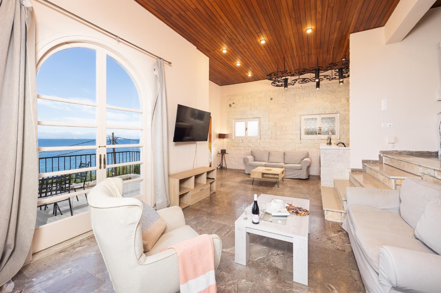 Living room with sofas, ornamental fireplace, A/C, WiFi internet, satellite TV, and sea views