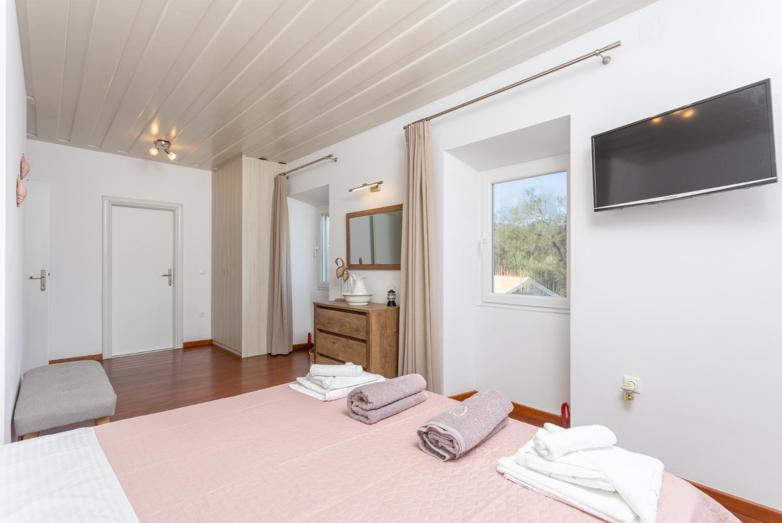 Double bedroom with en suite bathroom, A/C, and TV