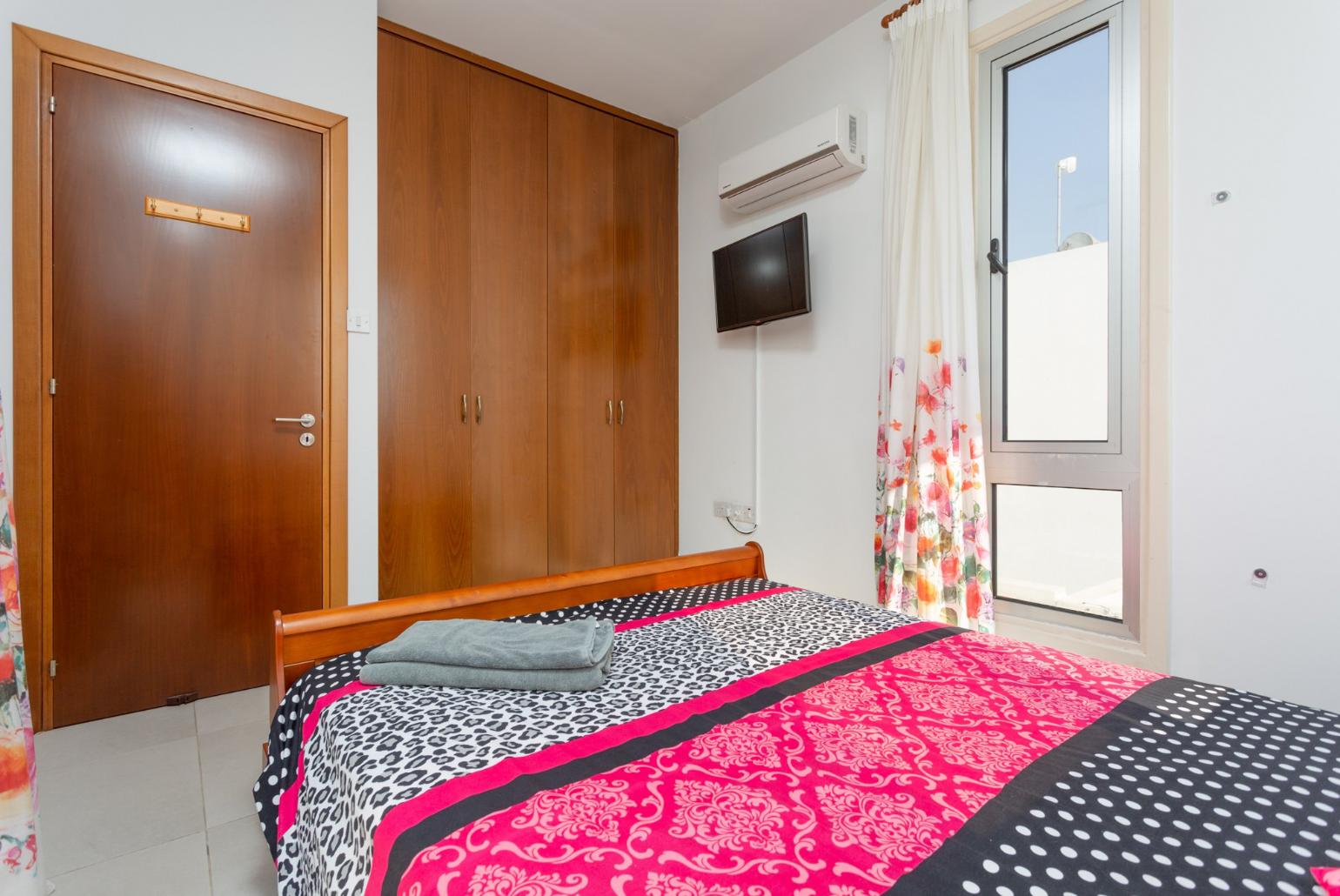 Double bedroom with A/C, satellite TV, and balcony access