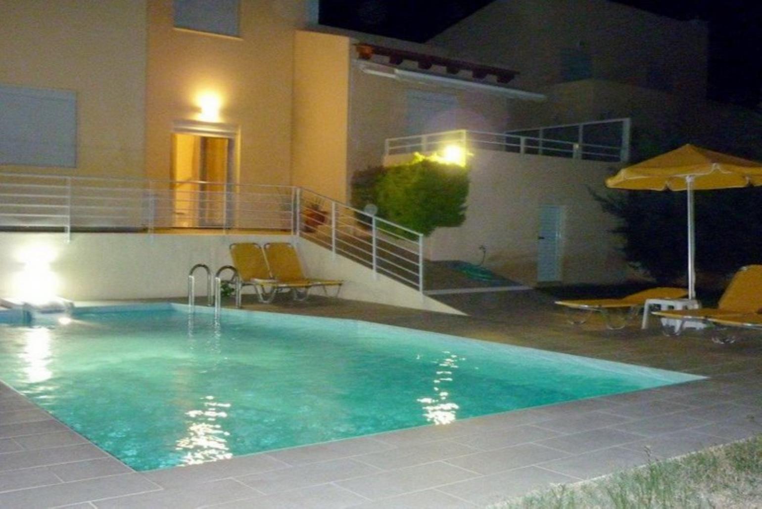 Beautiful villa with private pool, terrace, and lawn at night