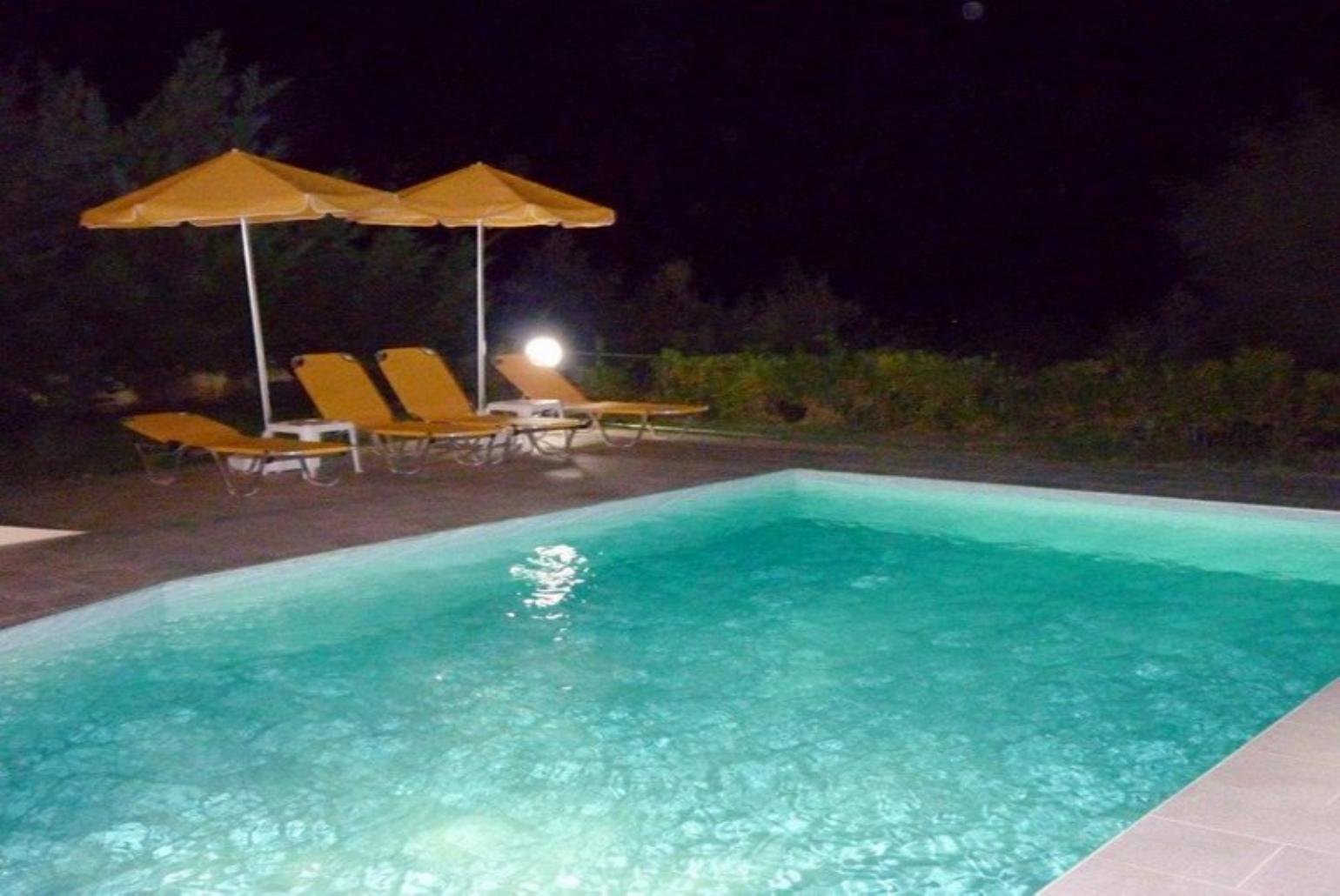 Beautiful villa with private pool, terrace, and lawn at night