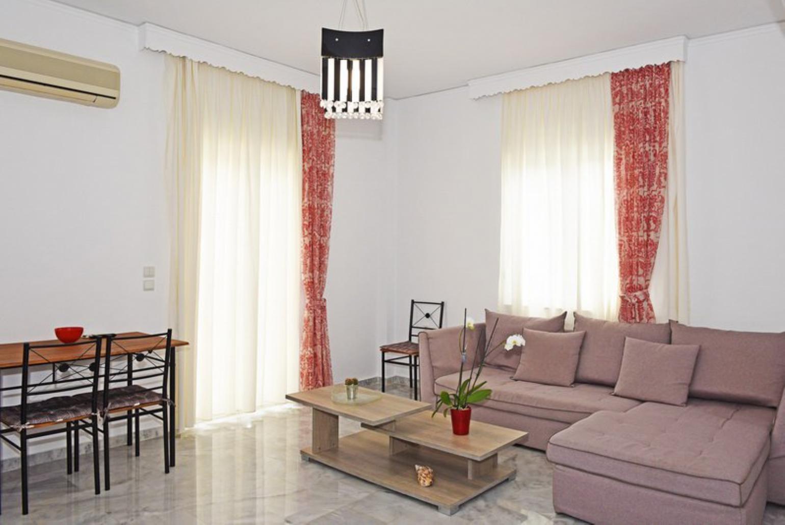 Open-plan living room with sofa, dining area, kitchen