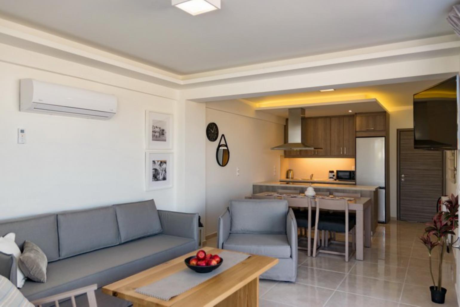 Open-plan living room with sofas, dining area, kitchen, A/C, WiFi internet, satellite TV, and sea views