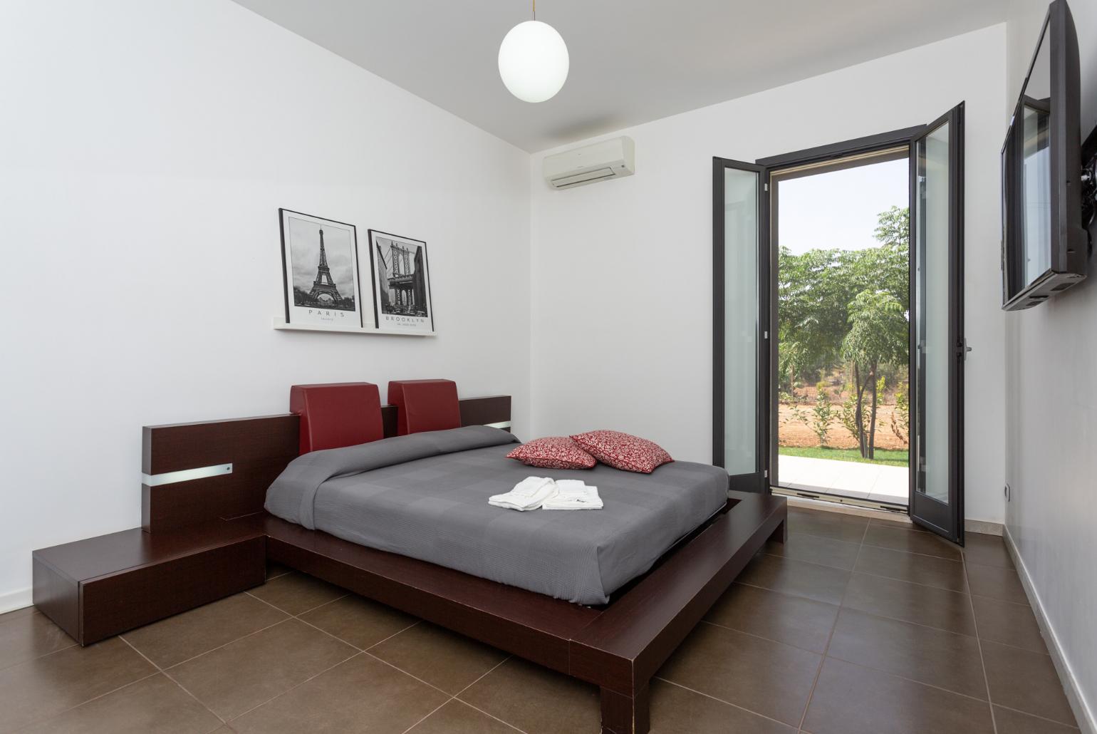 Double bedroom with en suite bathroom, A/C, TV, walk-in wardrobe, and terrace access