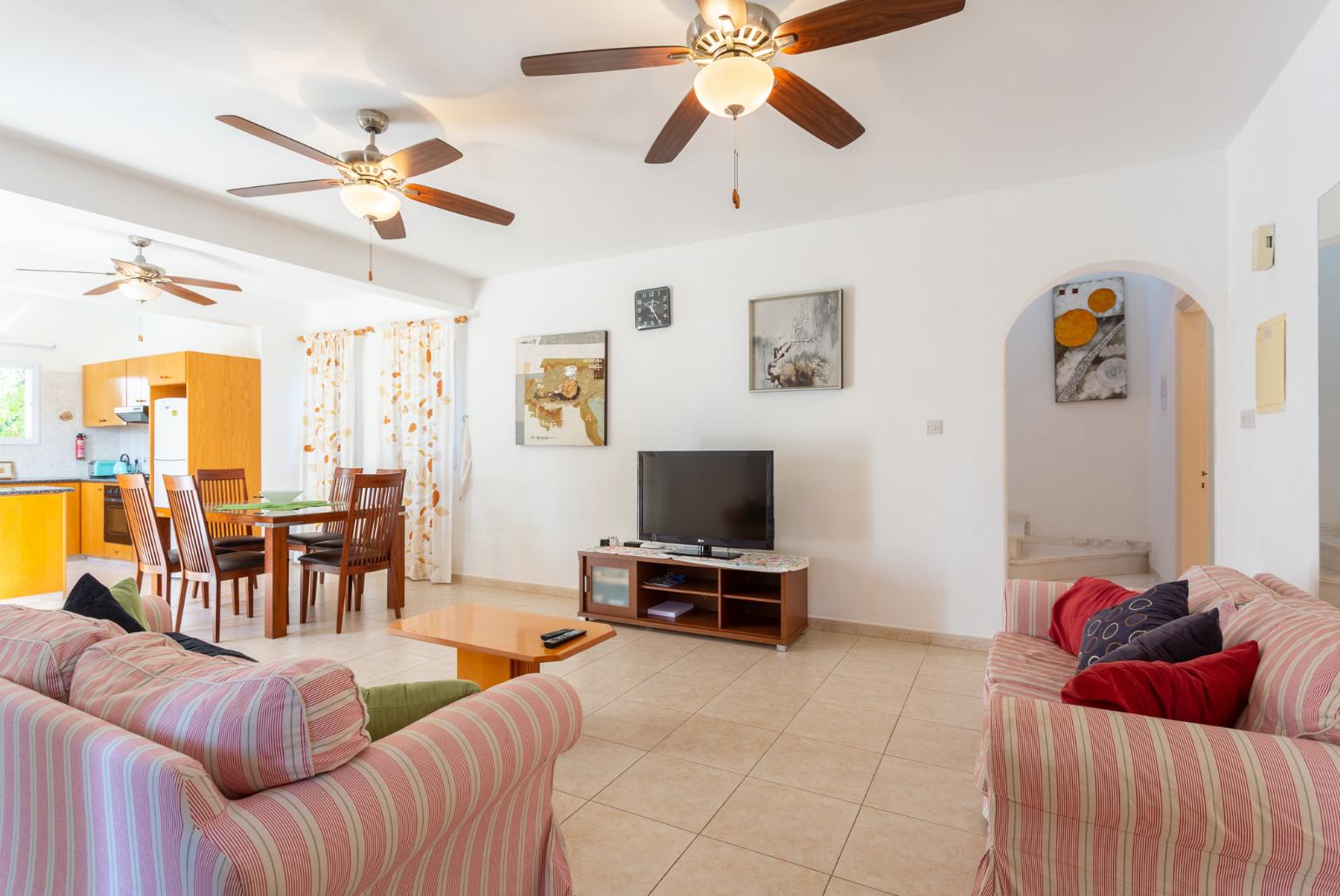 Open-plan living room with sofas, dining area, kitchen, WiFi internet, satellite TV, DVD player, and pool terrace access