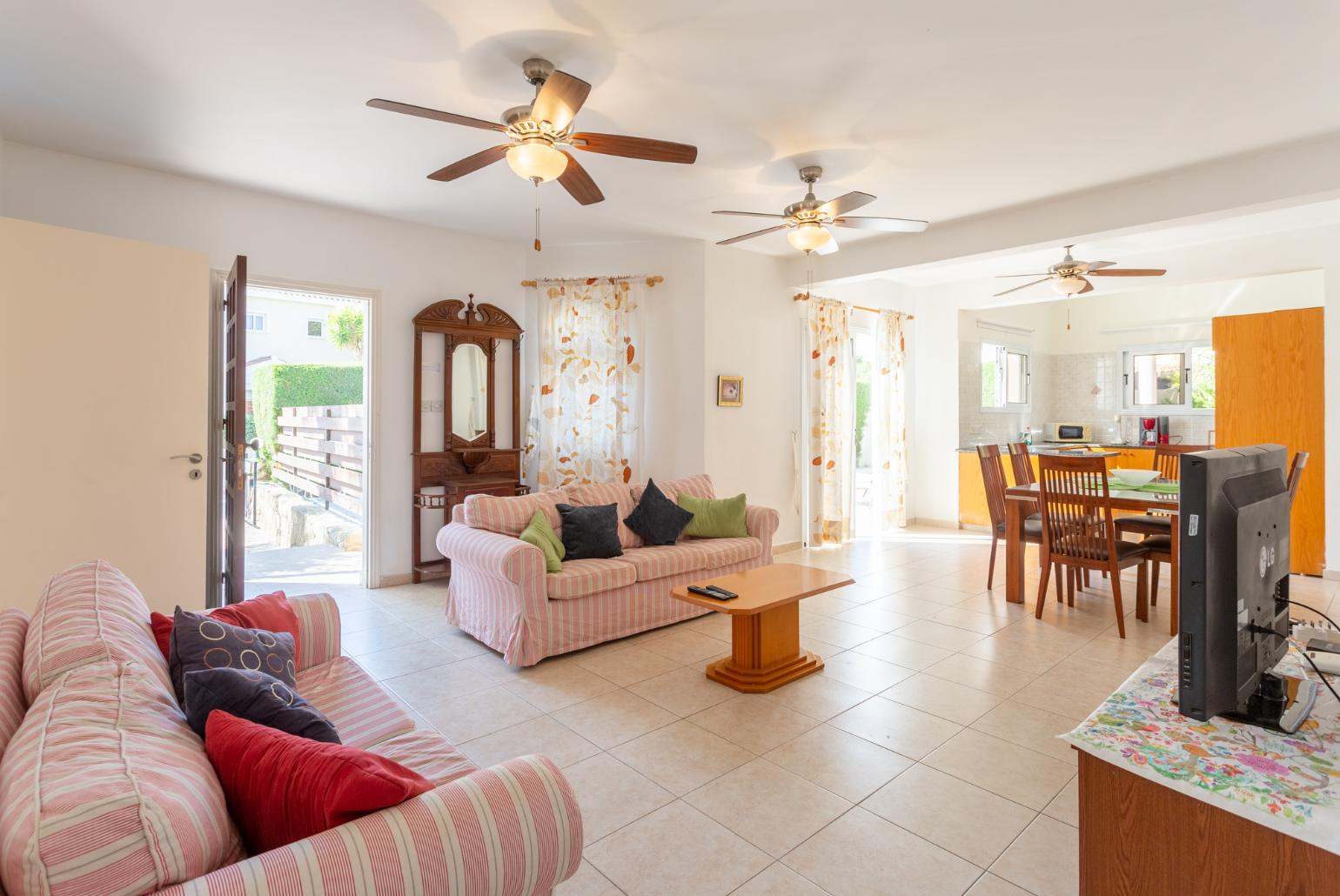 Open-plan living room with sofas, dining area, kitchen, WiFi internet, satellite TV, DVD player, and pool terrace access