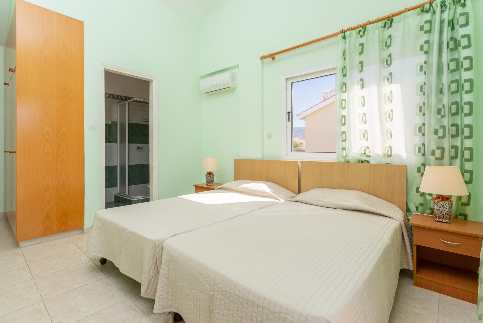 Twin bedroom with en suite bathroom, A/C, and balcony access