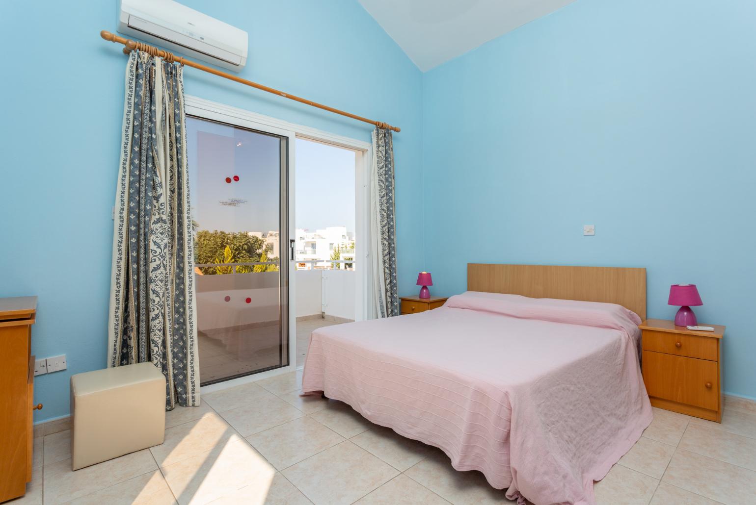 Double bedroom with en suite bathroom, A/C, and balcony access