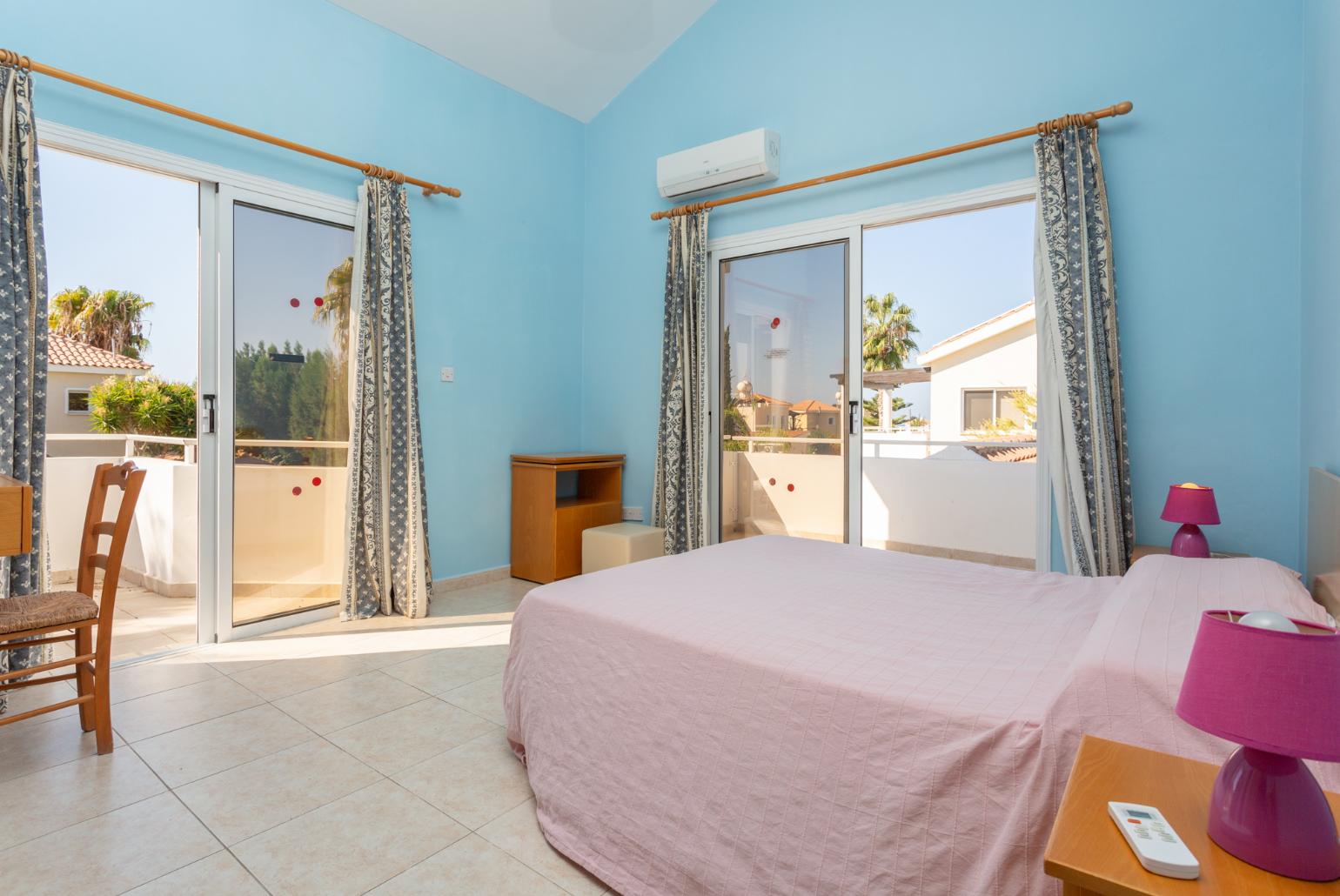 Double bedroom with en suite bathroom, A/C, and balcony access