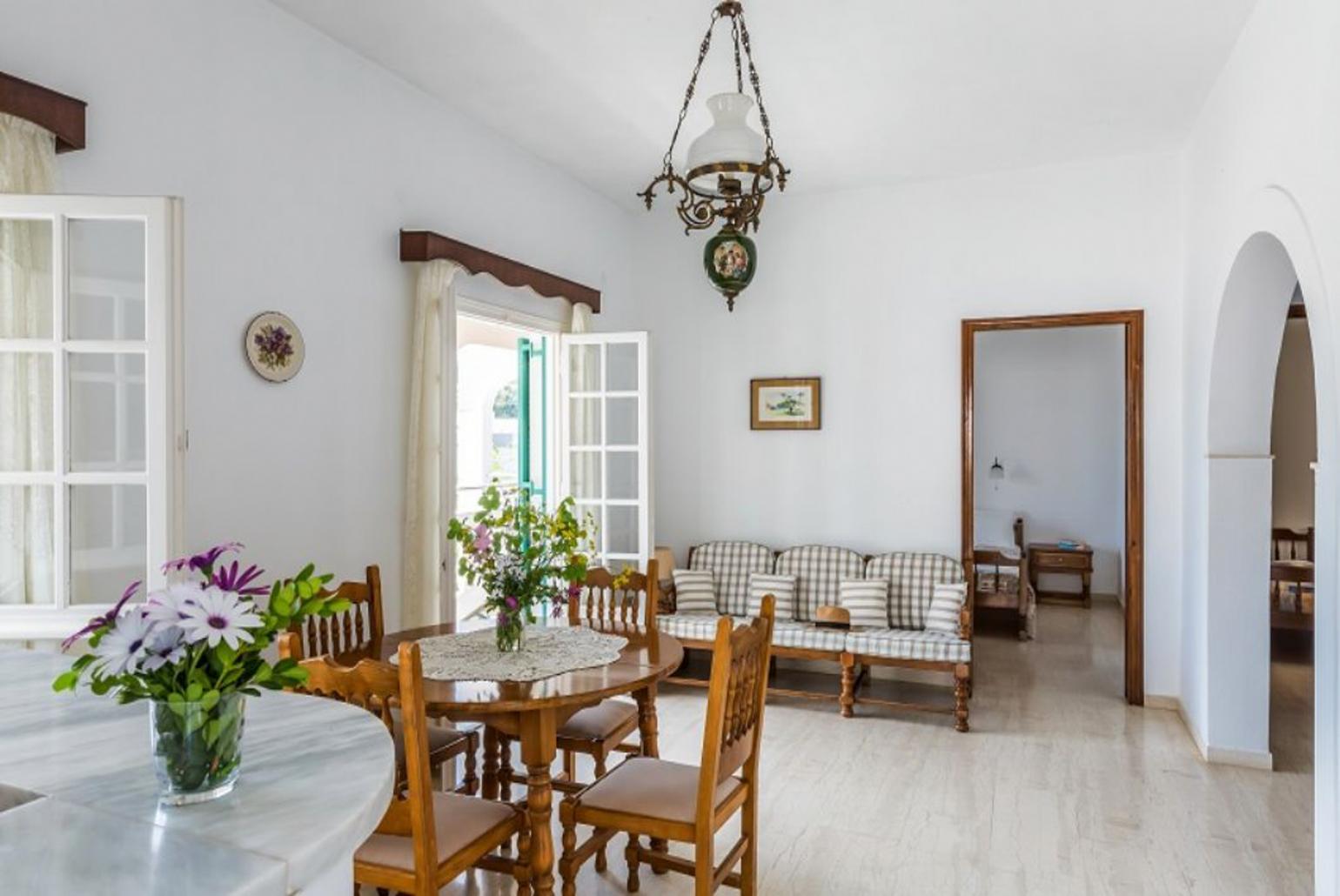 Open-plan living room with sofa, dining area, kitchen, WiFi internet, and terrace access with sea views