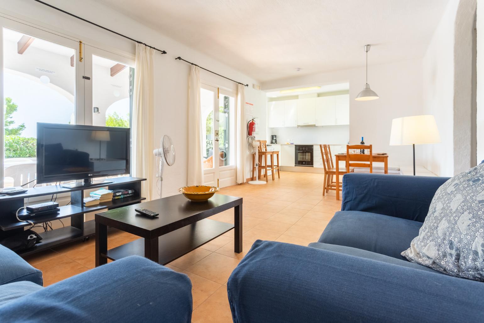 Open-plan living room with sofas, dining area, kitchen, A/C, WiFi internet, satellite TV, and terrace access