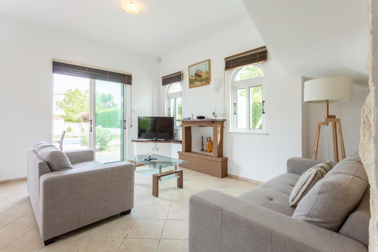 Open-plan living room with sofas, dining area, kitchen, ornamental fireplace, WiFi internet, satellite TV, and pool terrace access