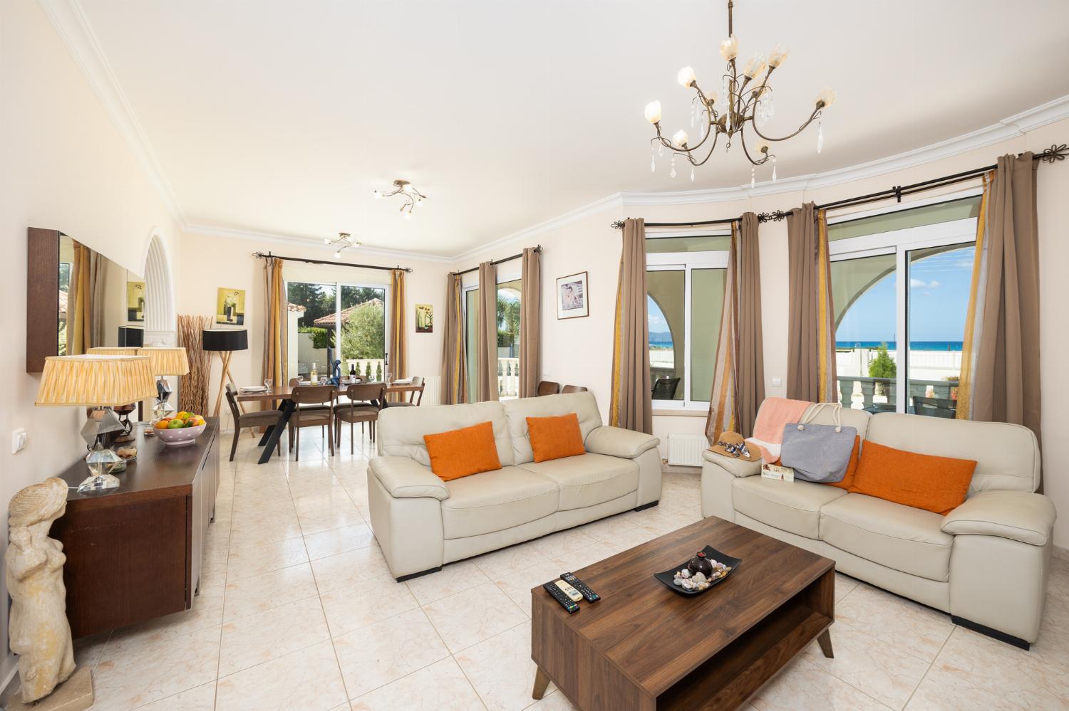 Open-plan living room with sofas, dining area, kitchen, A/C, WiFi internet, satellite TV, and sea views