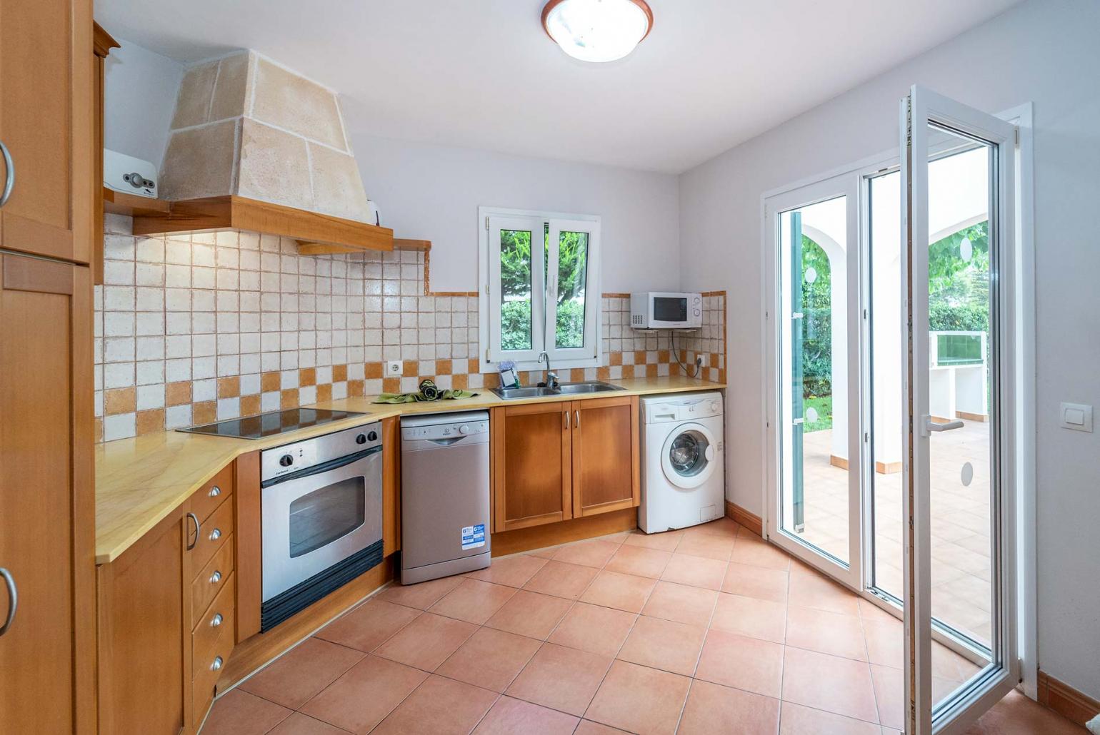 Equipped open plan kitchen with terrace access