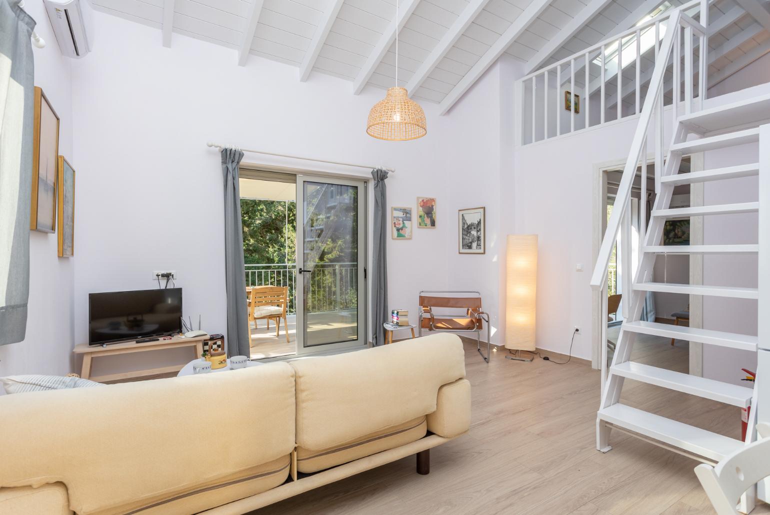 Open-plan living room with sofa, dining area, kitchen, mezzanine, A/C, WiFi internet, and satellite TV