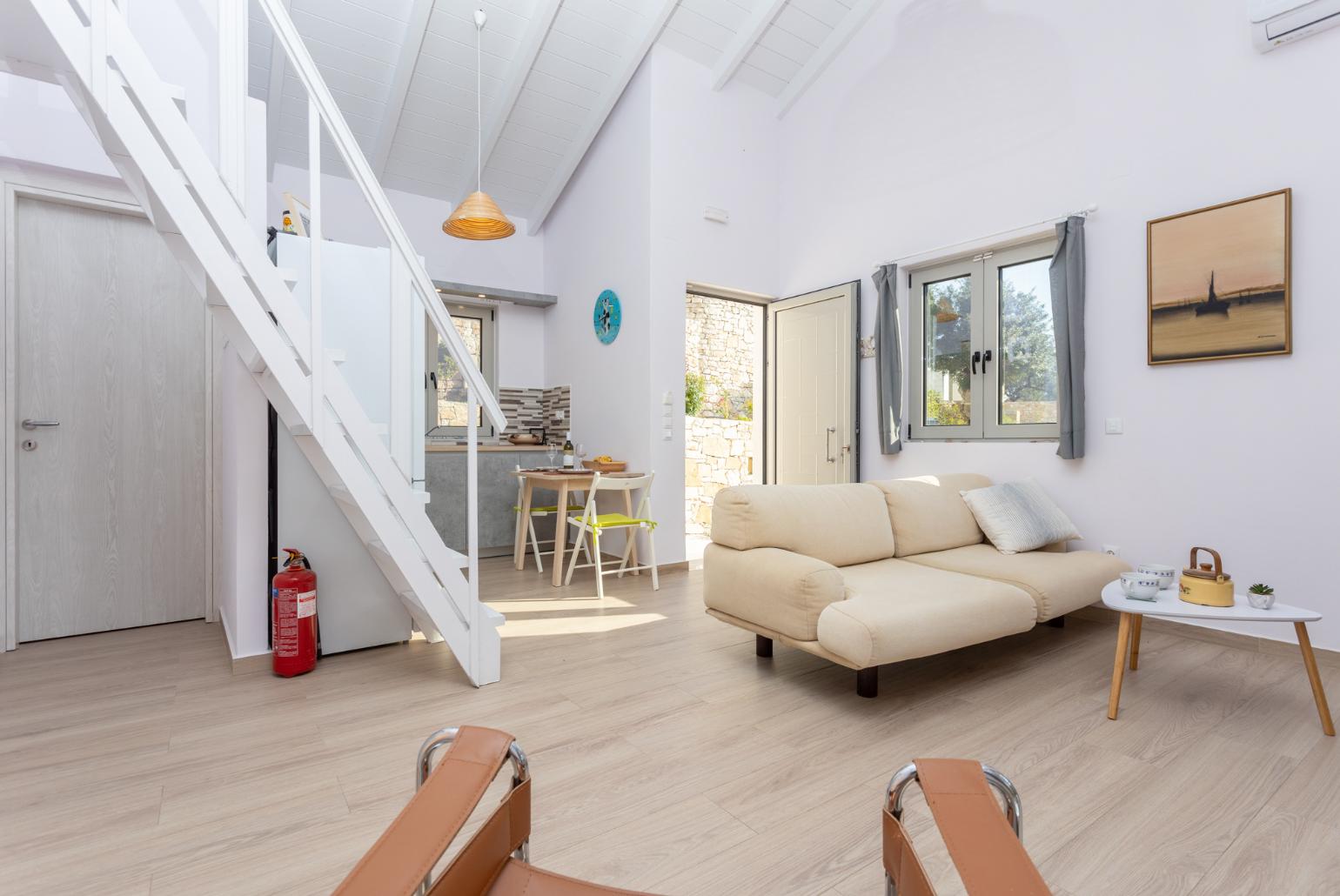 Open-plan living room with sofa, dining area, kitchen, mezzanine, A/C, WiFi internet, and satellite TV