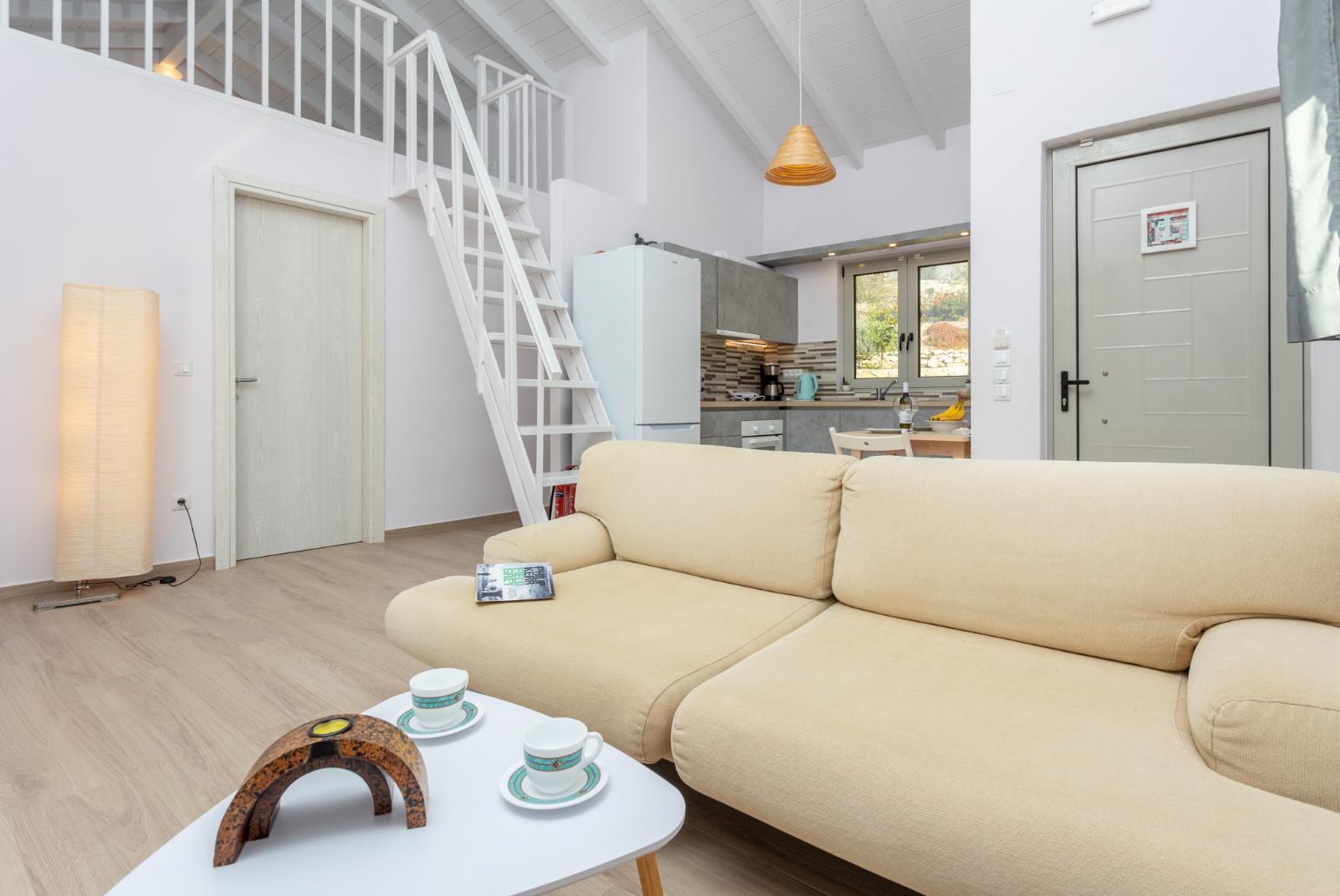 Open-plan living room with sofa, dining area, mezzanine, kitchen, A/C, WiFi internet, and satellite TV