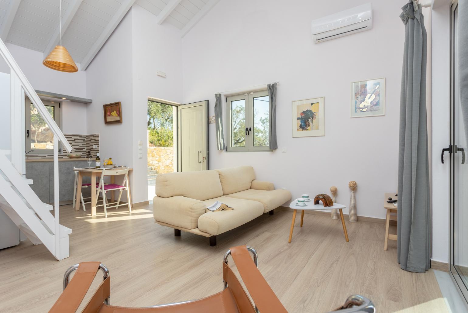 Open-plan living room with sofa, dining area, mezzanine, kitchen, A/C, WiFi internet, and satellite TV