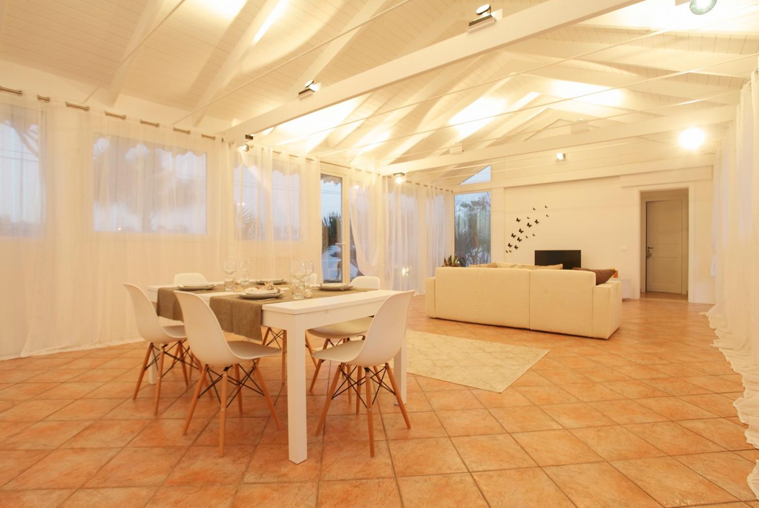 Living room with sofa, dining area, A/C, WiFi internet, and satellite TV