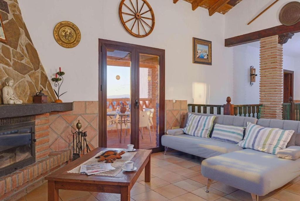 Open-plan living room with sofas, dining areas, kitchen, ornamental fireplace with panoramic sea views