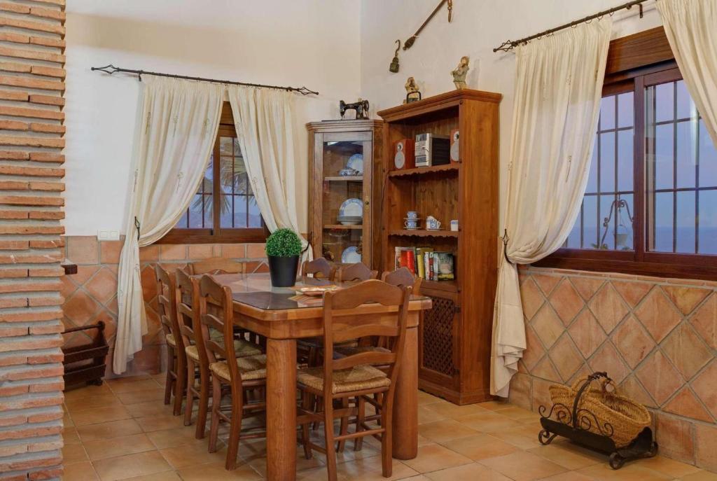 Open-plan living room with sofas, dining areas, kitchen, ornamental fireplace with panoramic sea views