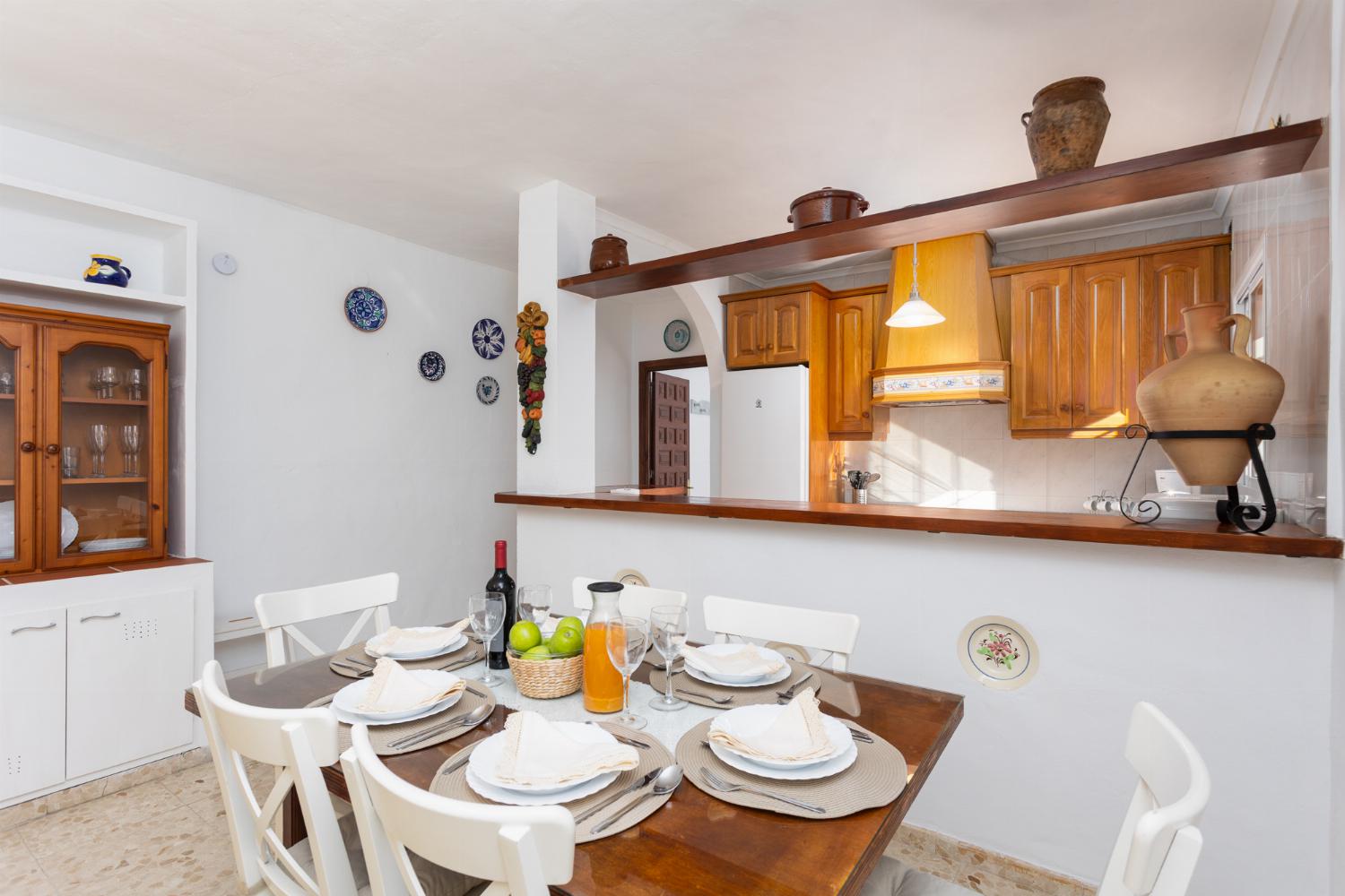 Open-plan living room with sofas, dining area, kitchen, ornamental fireplace, A/C, WiFi internet, and satellite TV
